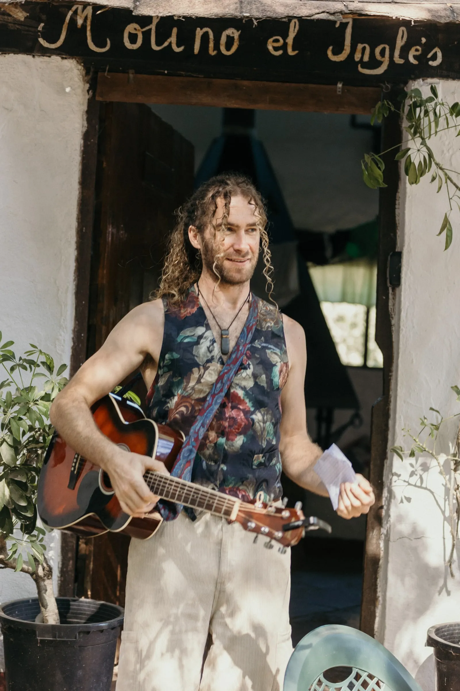 Friend with a guitar under the hand-painted 'Molino el Inglés' sign