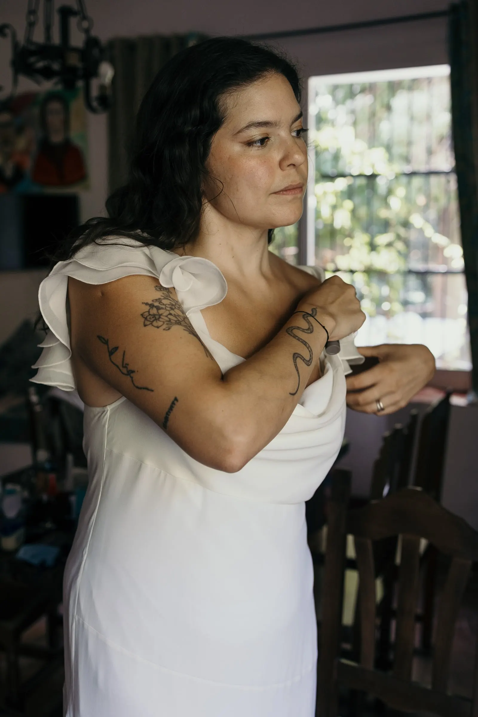 Bride adjusting the sleeve of her dress inside the mill house in Jimera de Líbar