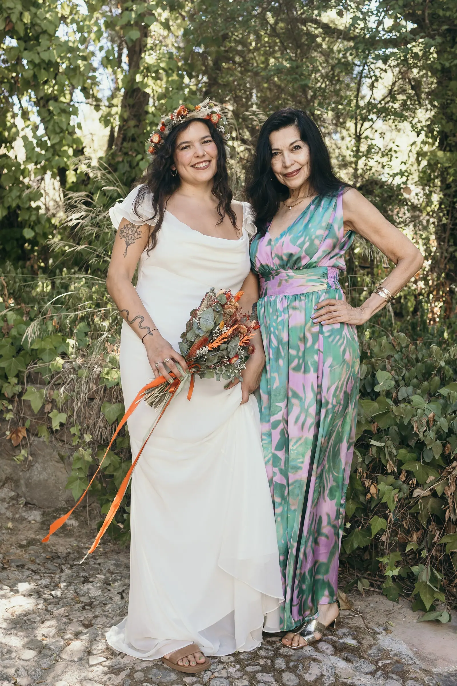 Bride with a woman in a floral jumpsuit among the greenery of the Guadiaro valley