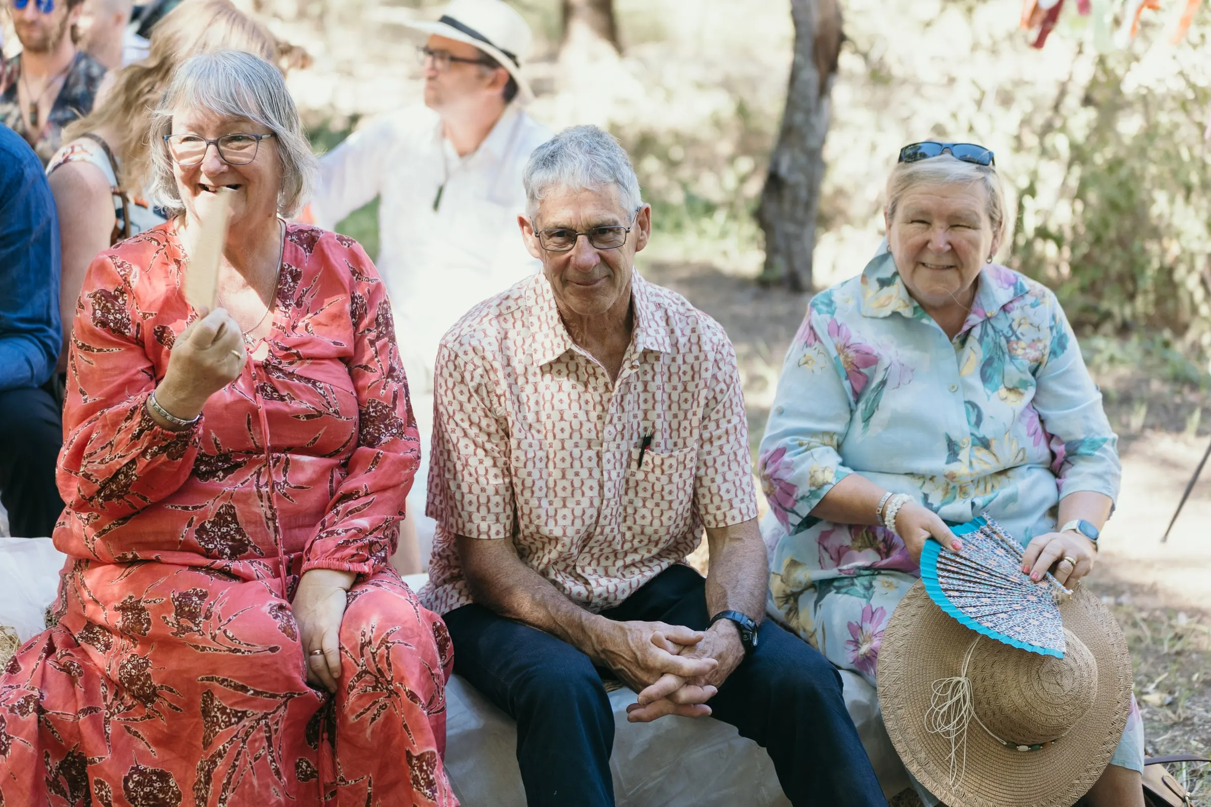Older guests laughing in the front row of the outdoor ceremony