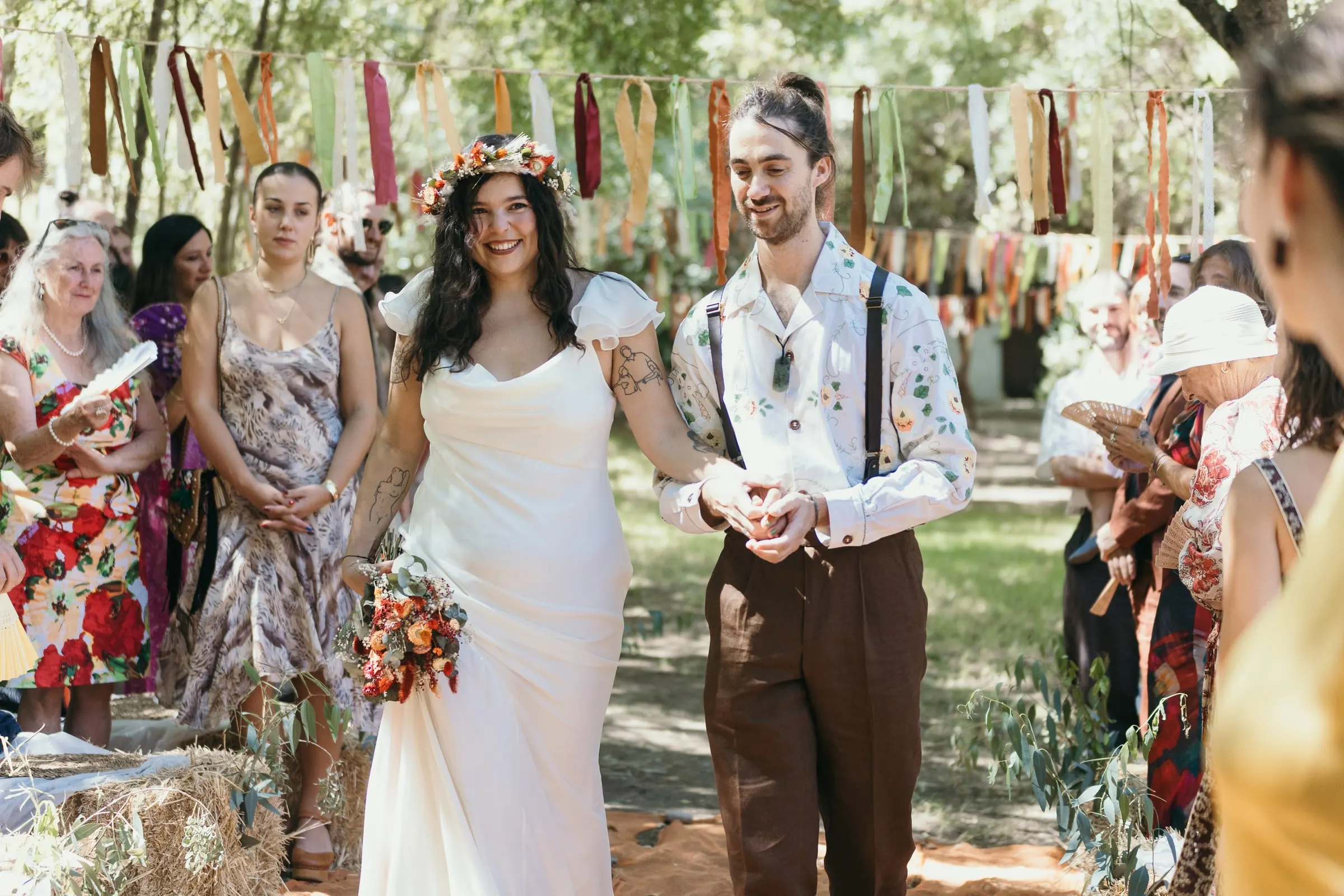 Couple walking down the aisle side by side among their guests in the Serranía de Ronda