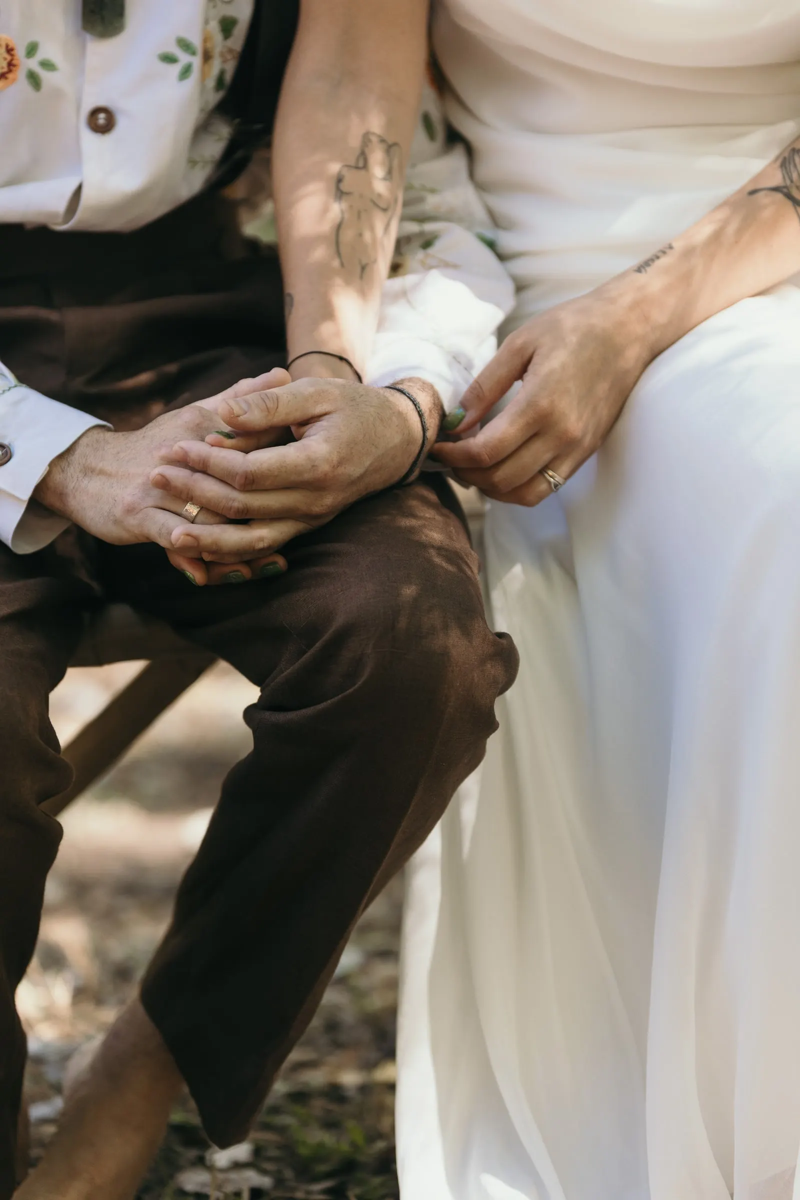 Close-up of the couple's hands resting on their laps