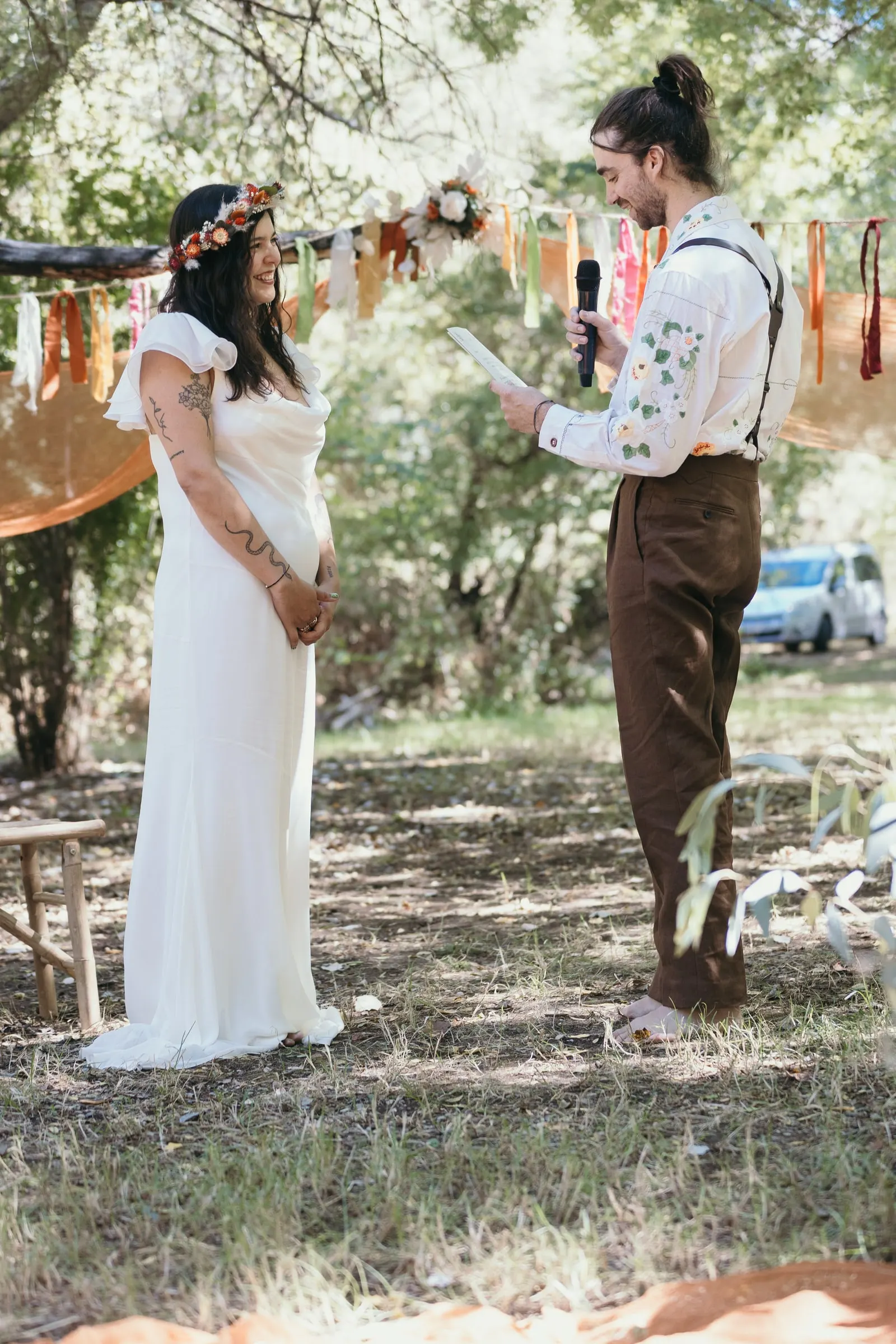Groom reading his vows to the bride under the garlands