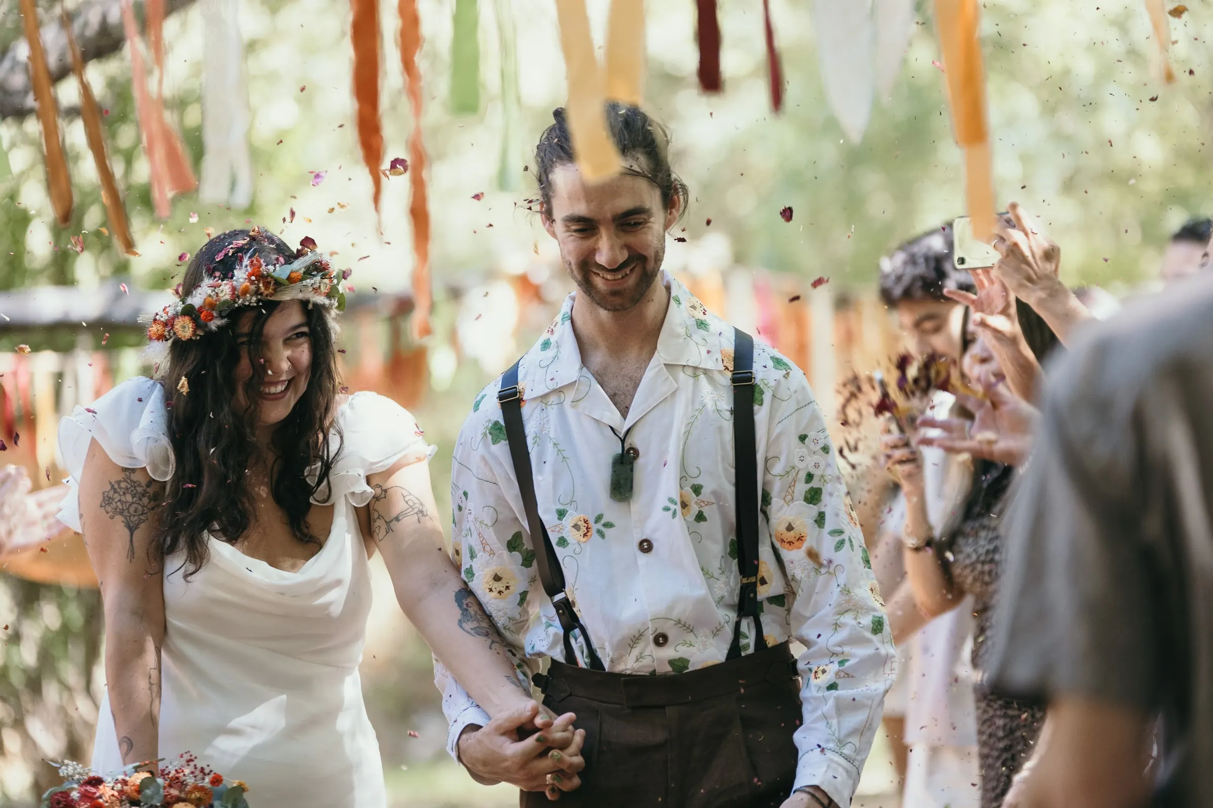 Newlyweds laughing under a shower of petals in Jimera de Líbar