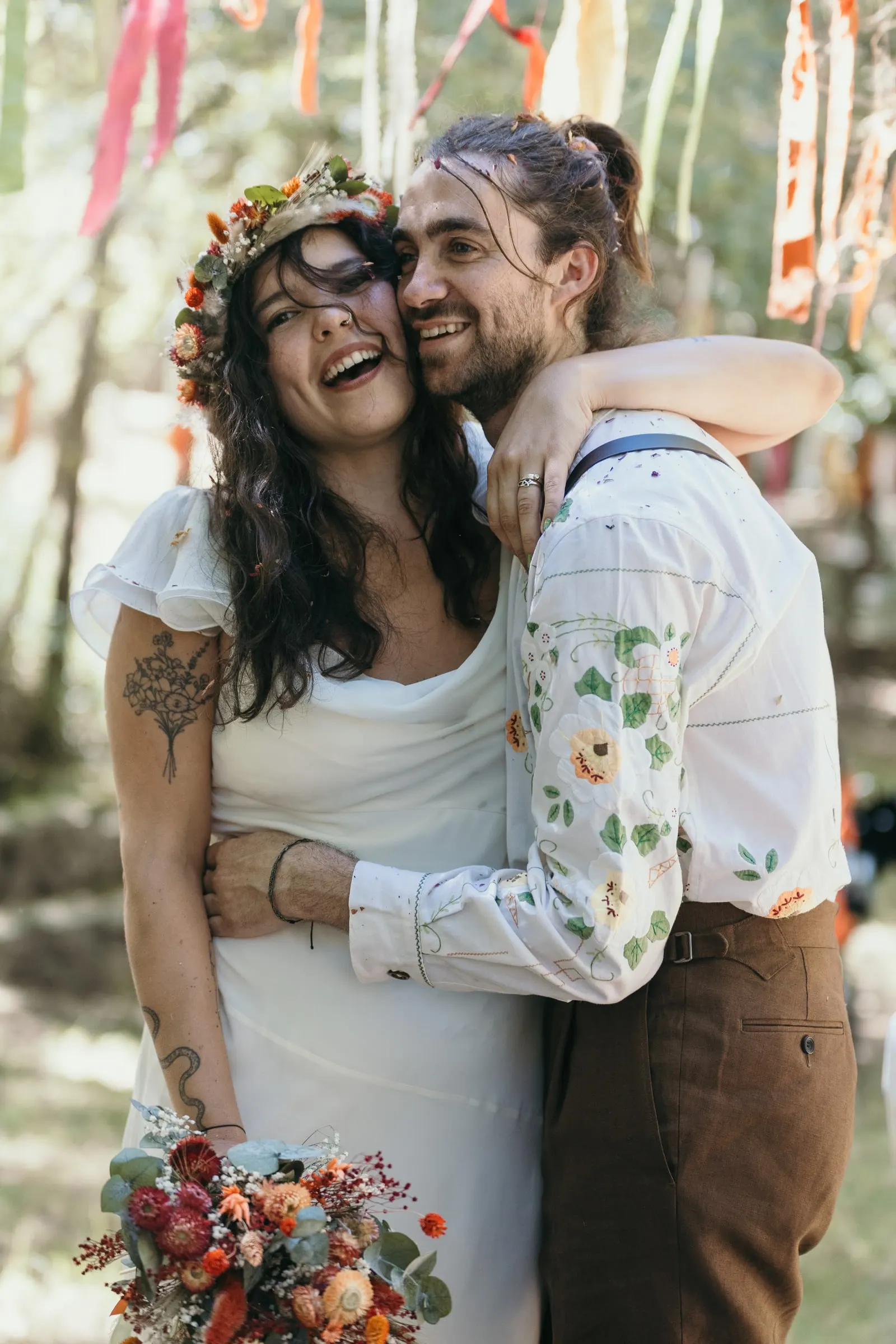 Bride laughing as the groom hugs her after the ceremony