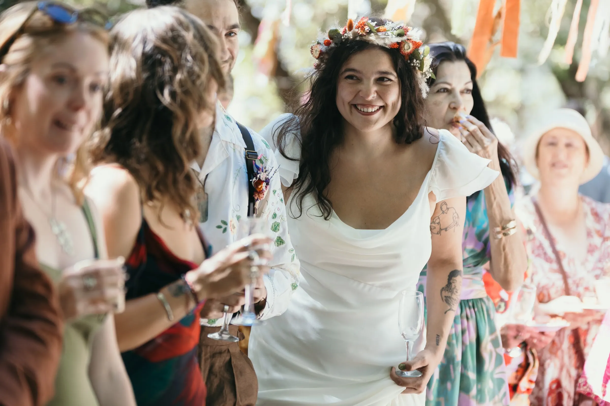 Bride laughing with a glass among her friends after the ceremony