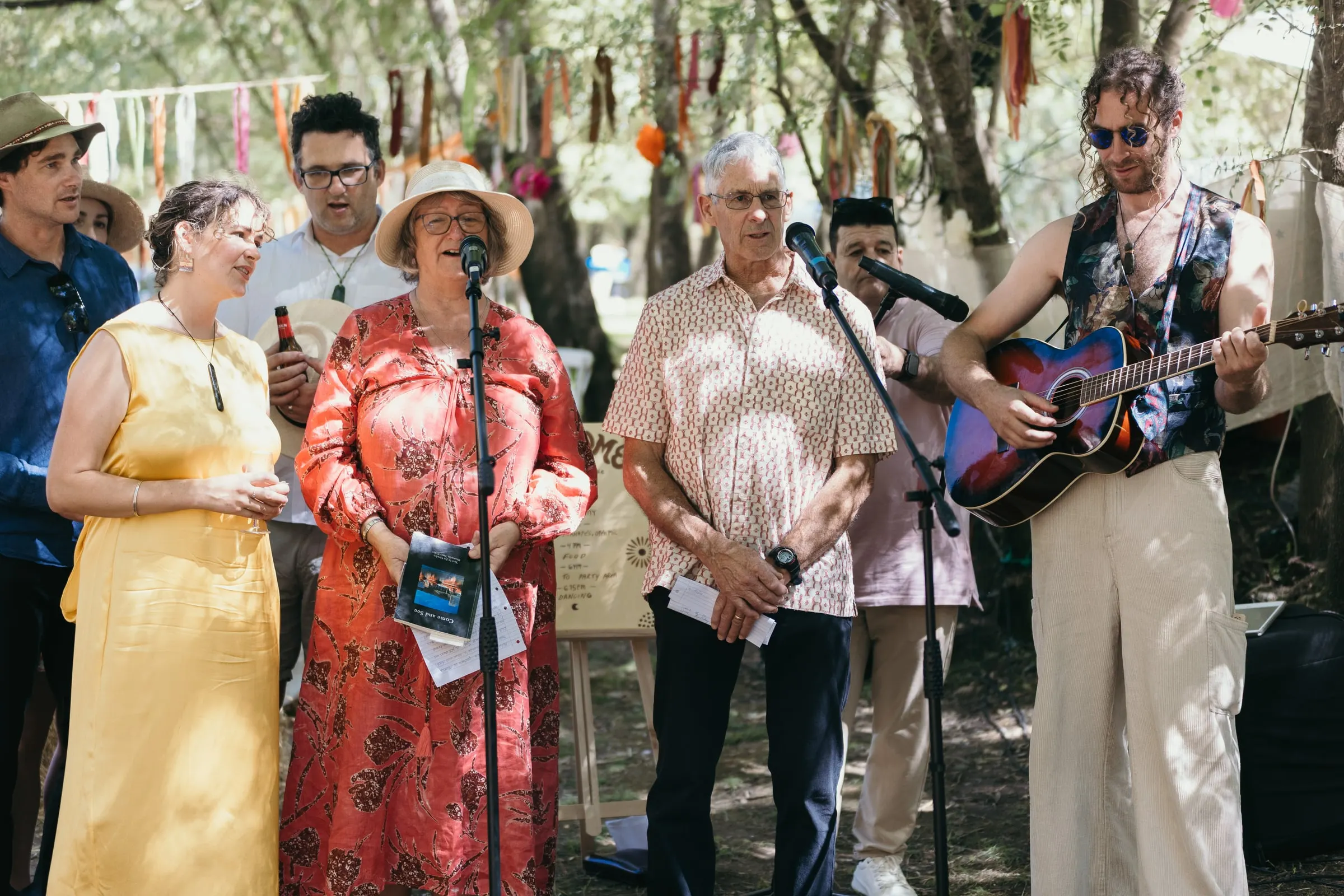 Family singing a song for the couple with a guitar and microphone