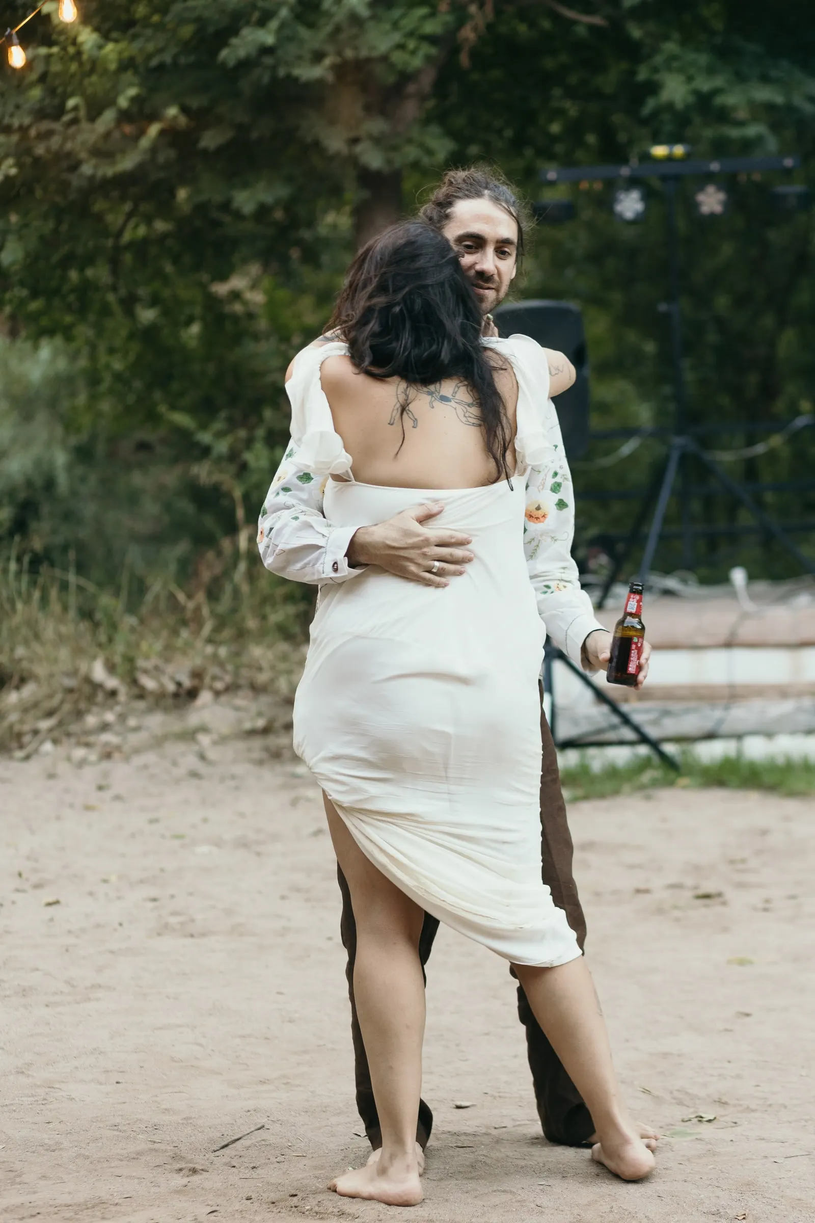 Groom holding the bride close as they dance into the evening