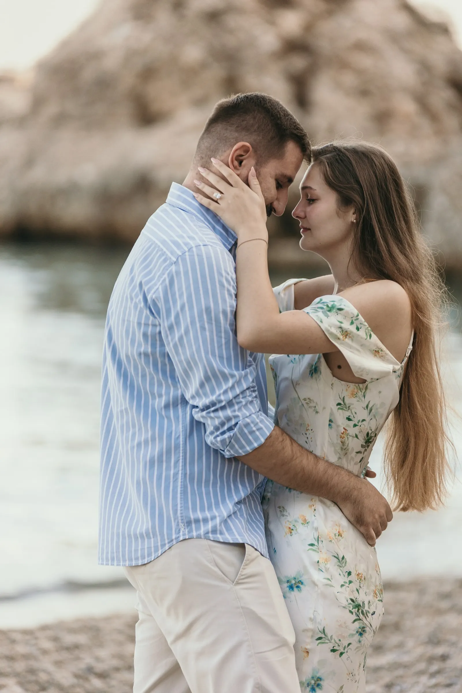 He cups her face and they touch foreheads beside the rocks, on the beach in Nerja