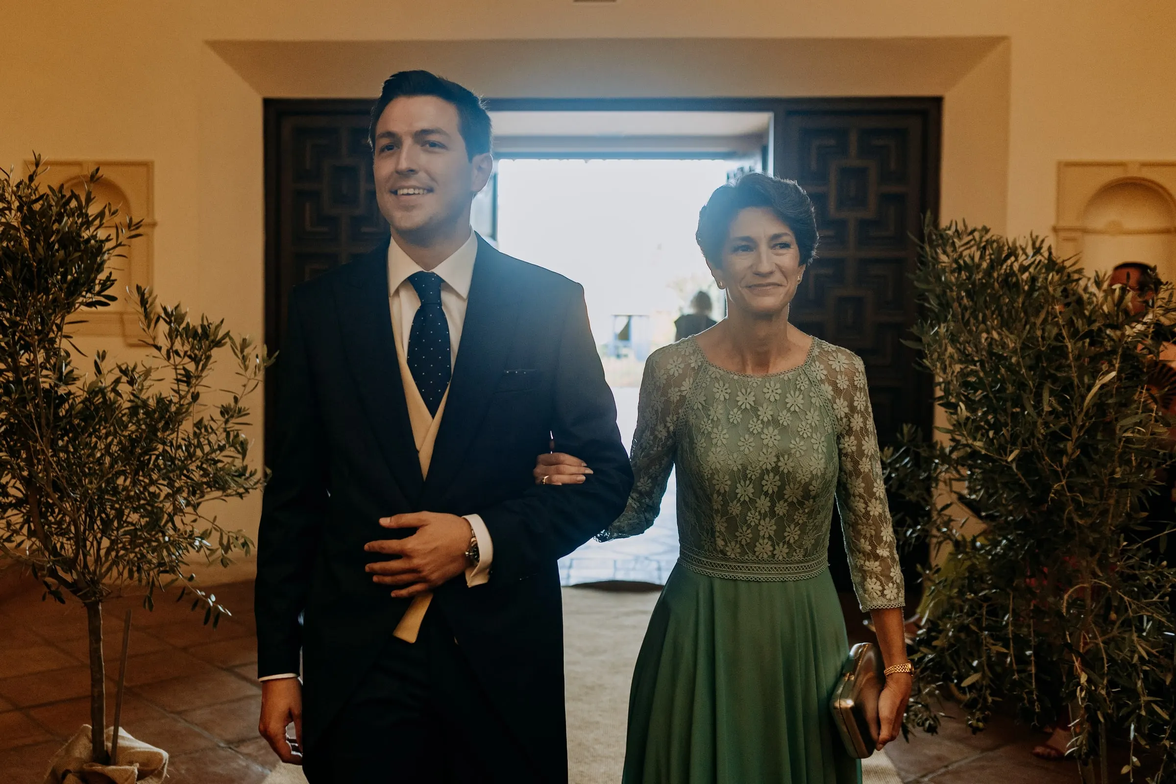 Groom arm in arm with a woman in green lace at the church door, Nuestra Señora de la Merced, Sotogrande