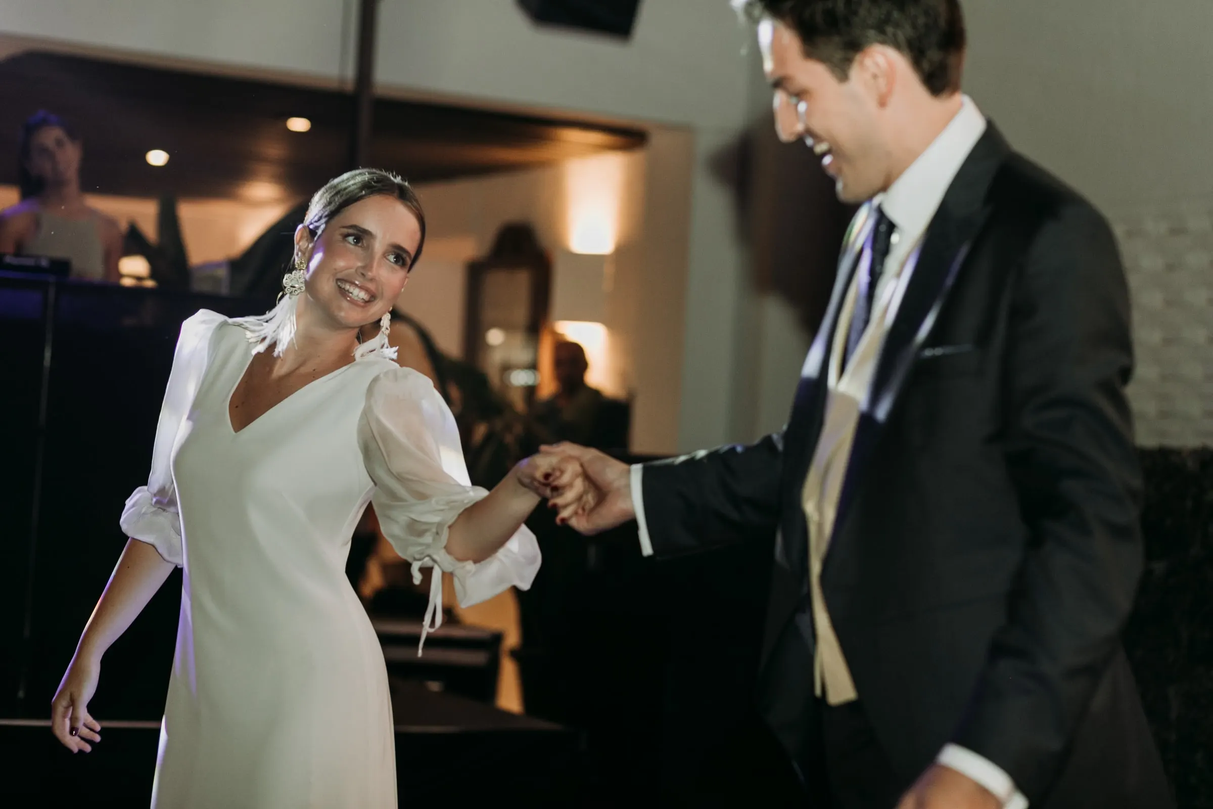 Bride twirling with a guest in a morning suit on the dance floor