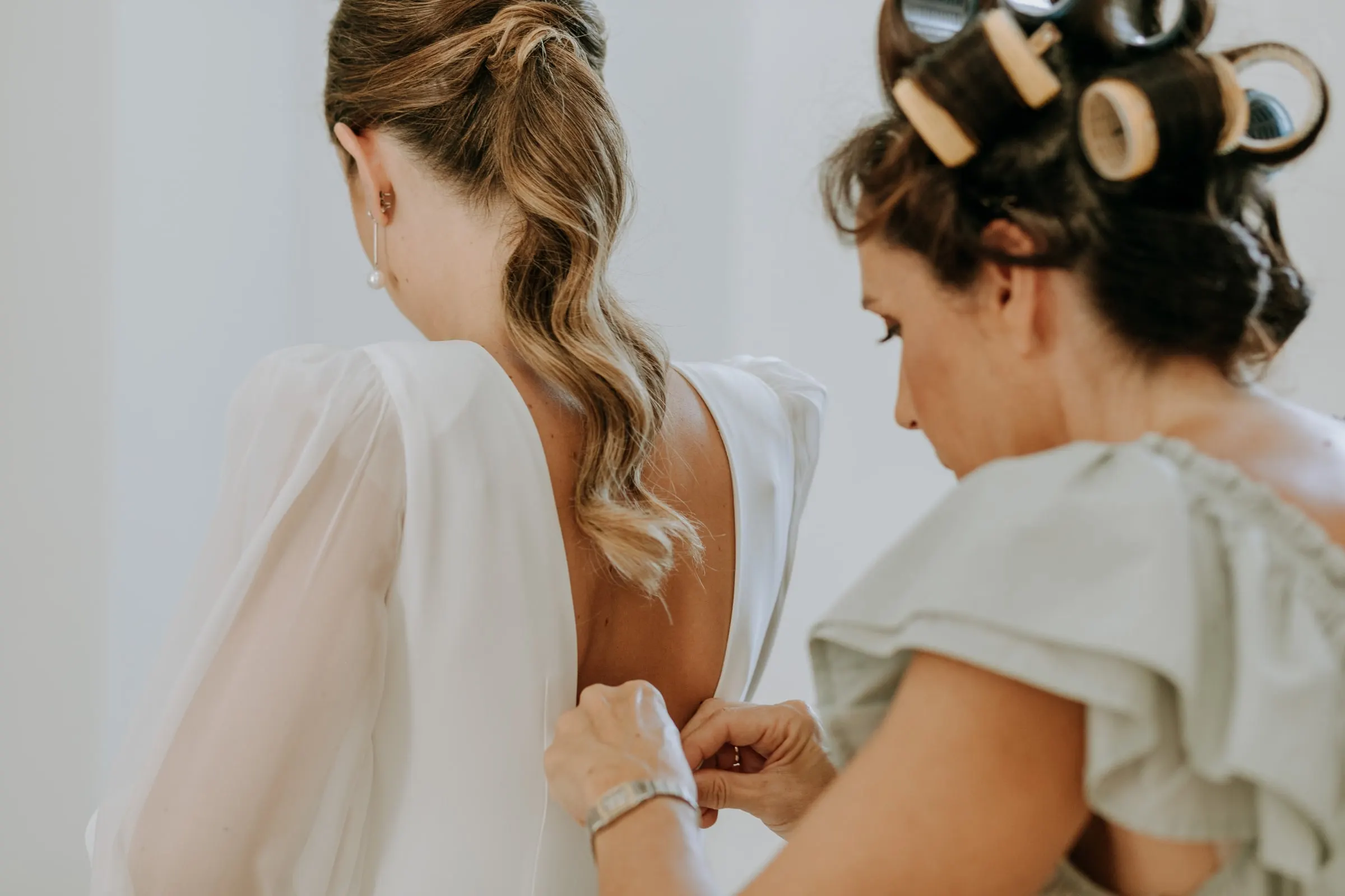 Buttoning up the back of the bride's dress