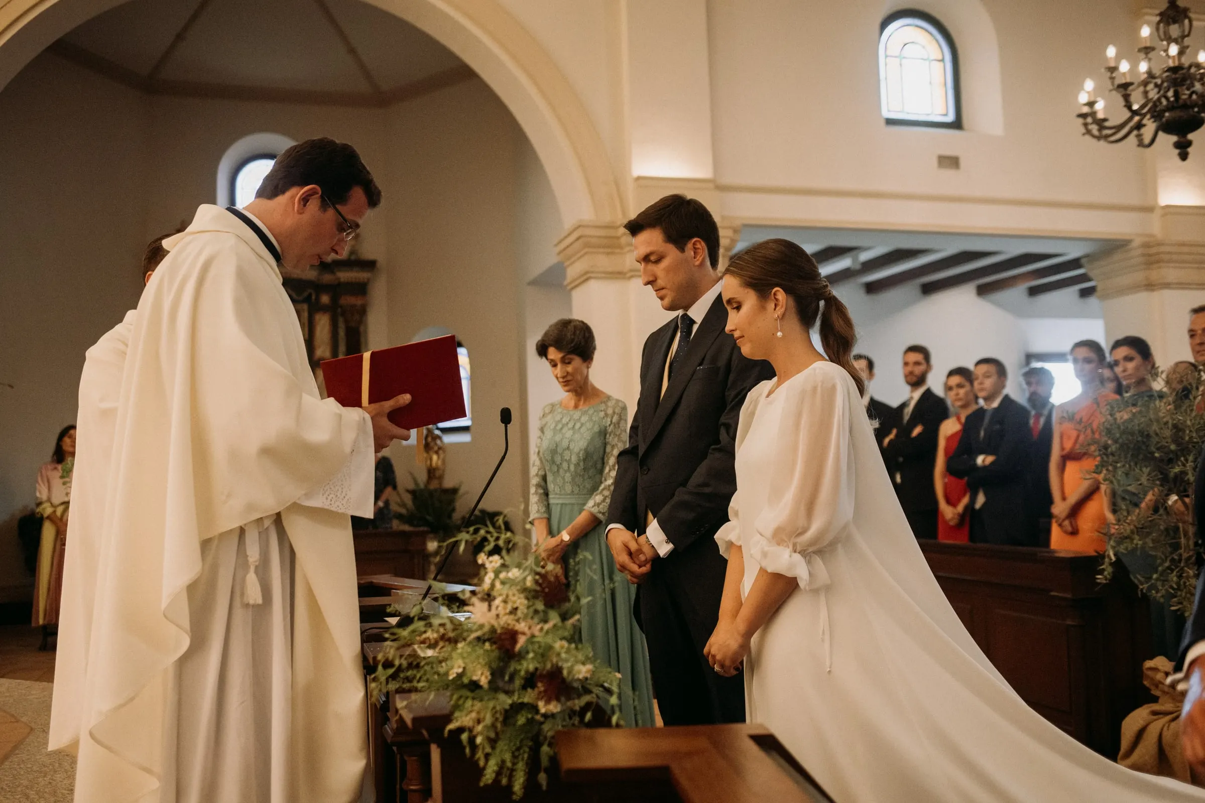 Bride and groom before the priest during the ceremony in Sotogrande
