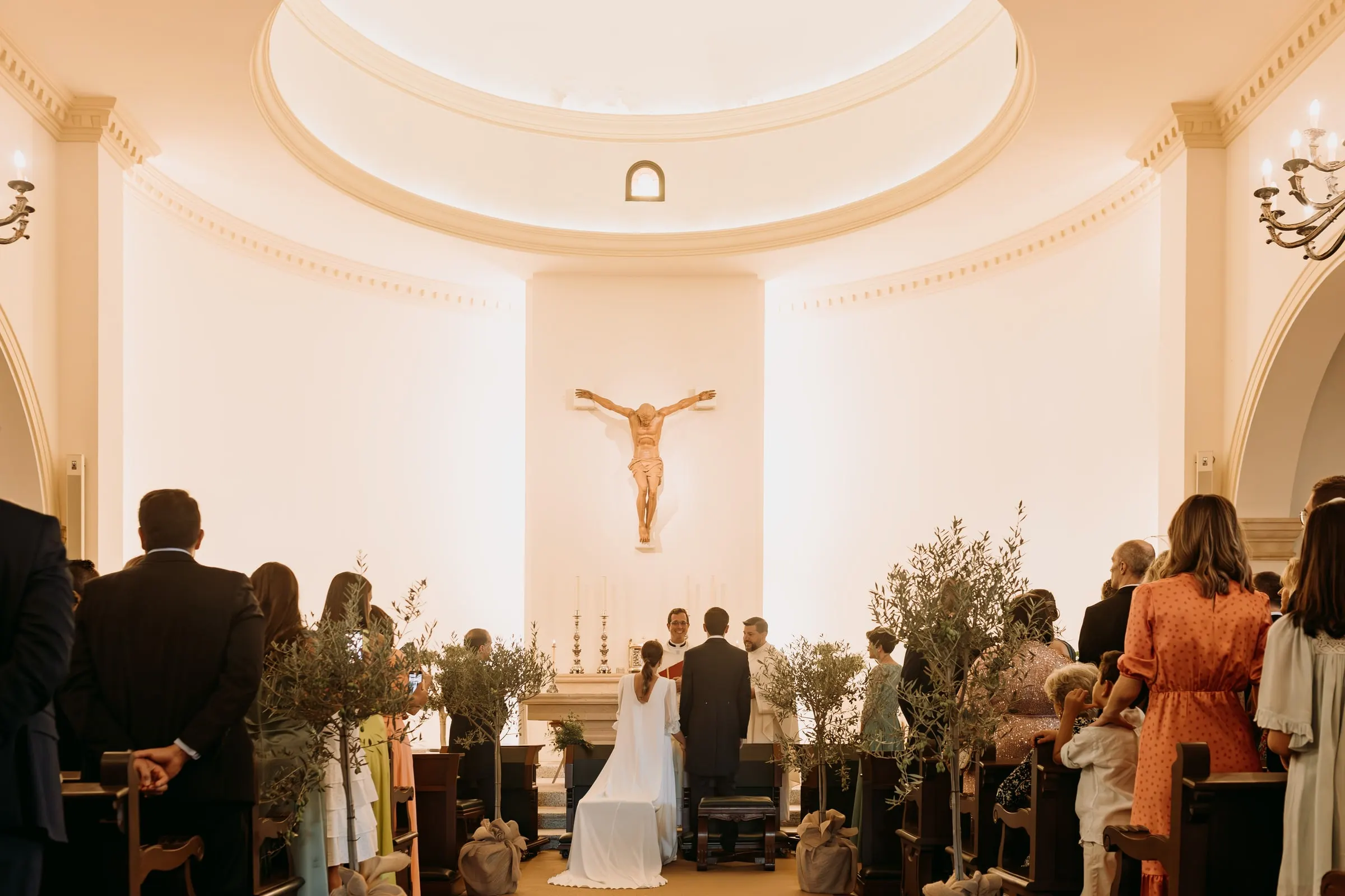 Wide view of the white apse and crucifix of Nuestra Señora de la Merced church during the wedding, Sotogrande