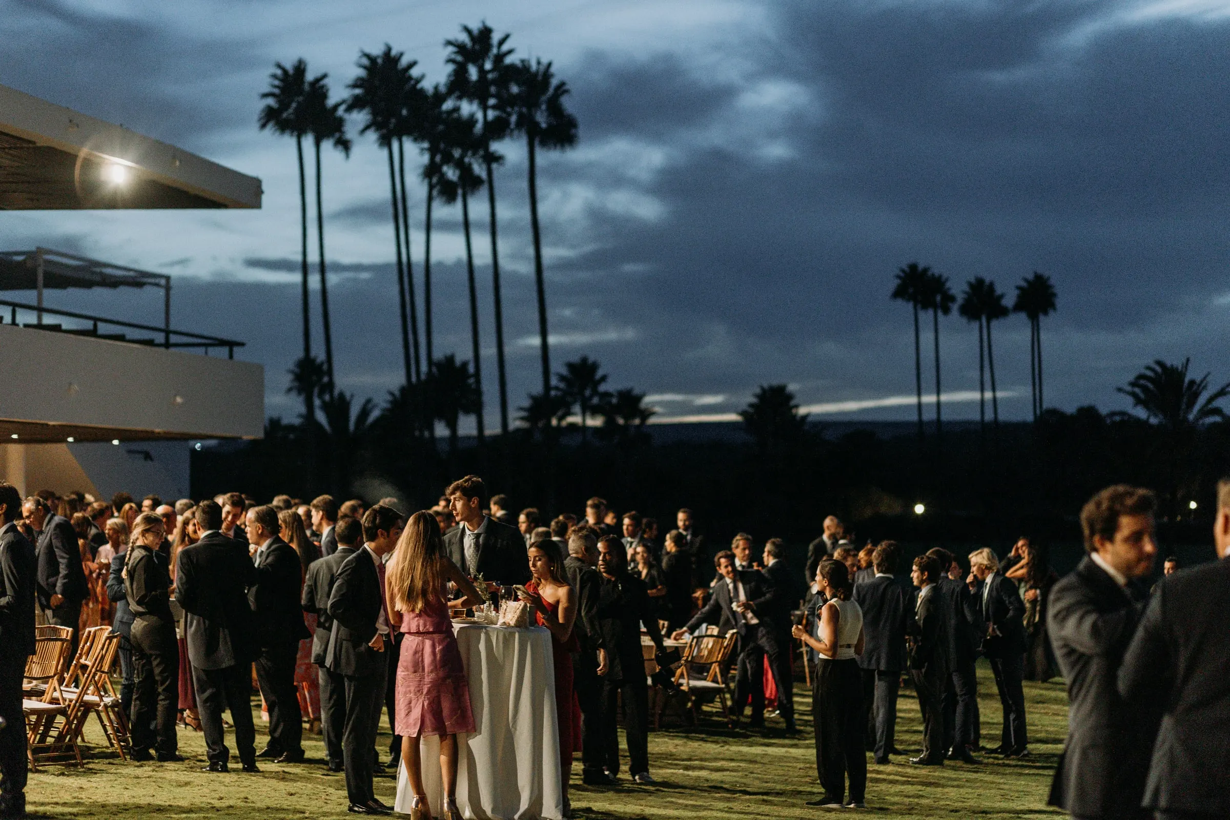 Cocktail on the lawn at blue hour under tall palm trees in Sotogrande