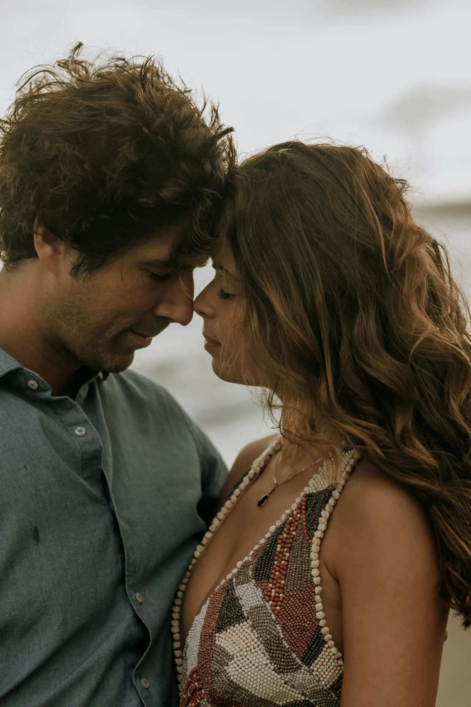 Close-up of the couple touching foreheads by the sea, pre-wedding session on the beach at Sotogrande