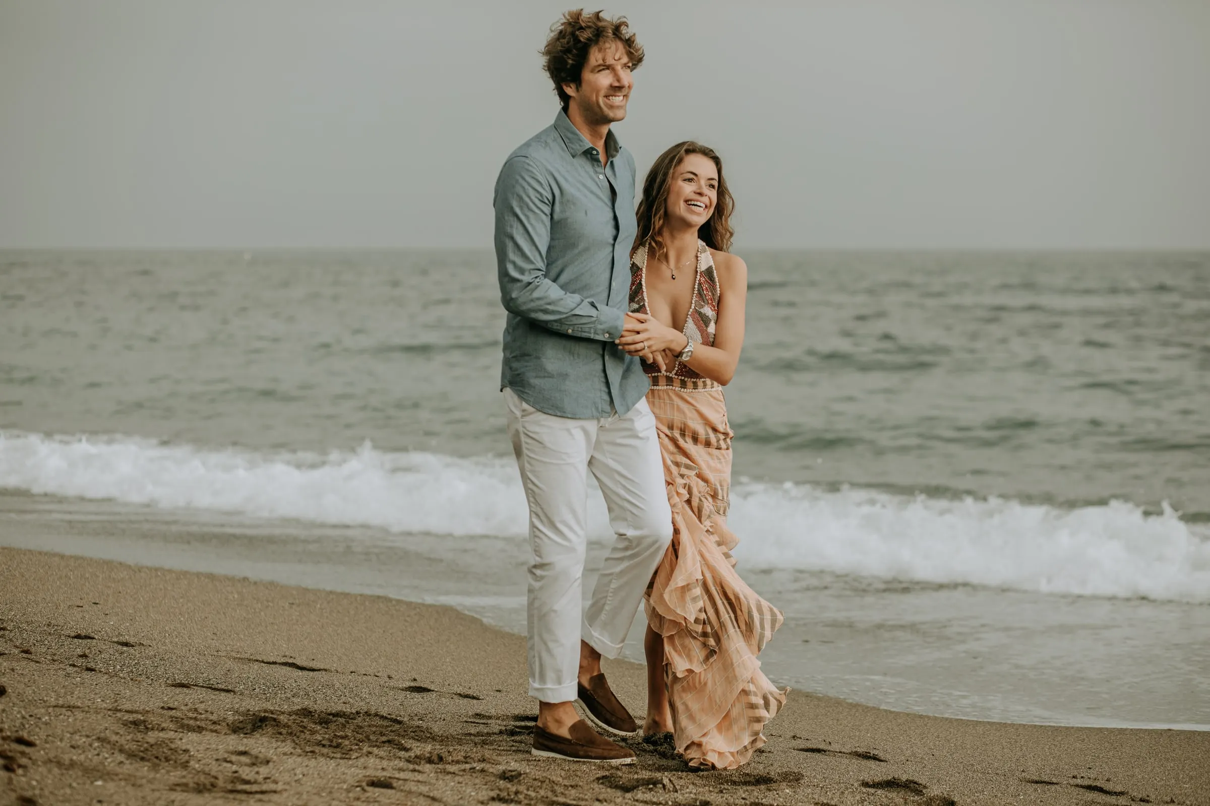 La pareja bailando descalza en la arena junto a las olas, sesión preboda en la playa de Sotogrande