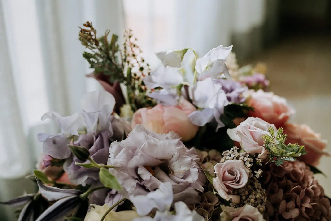 Bridal bouquet of lilac, pink and mauve flowers on a table