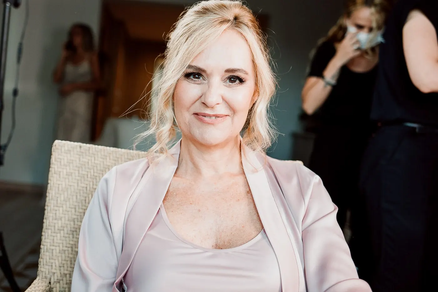 Bride in her robe smiling with her make-up done