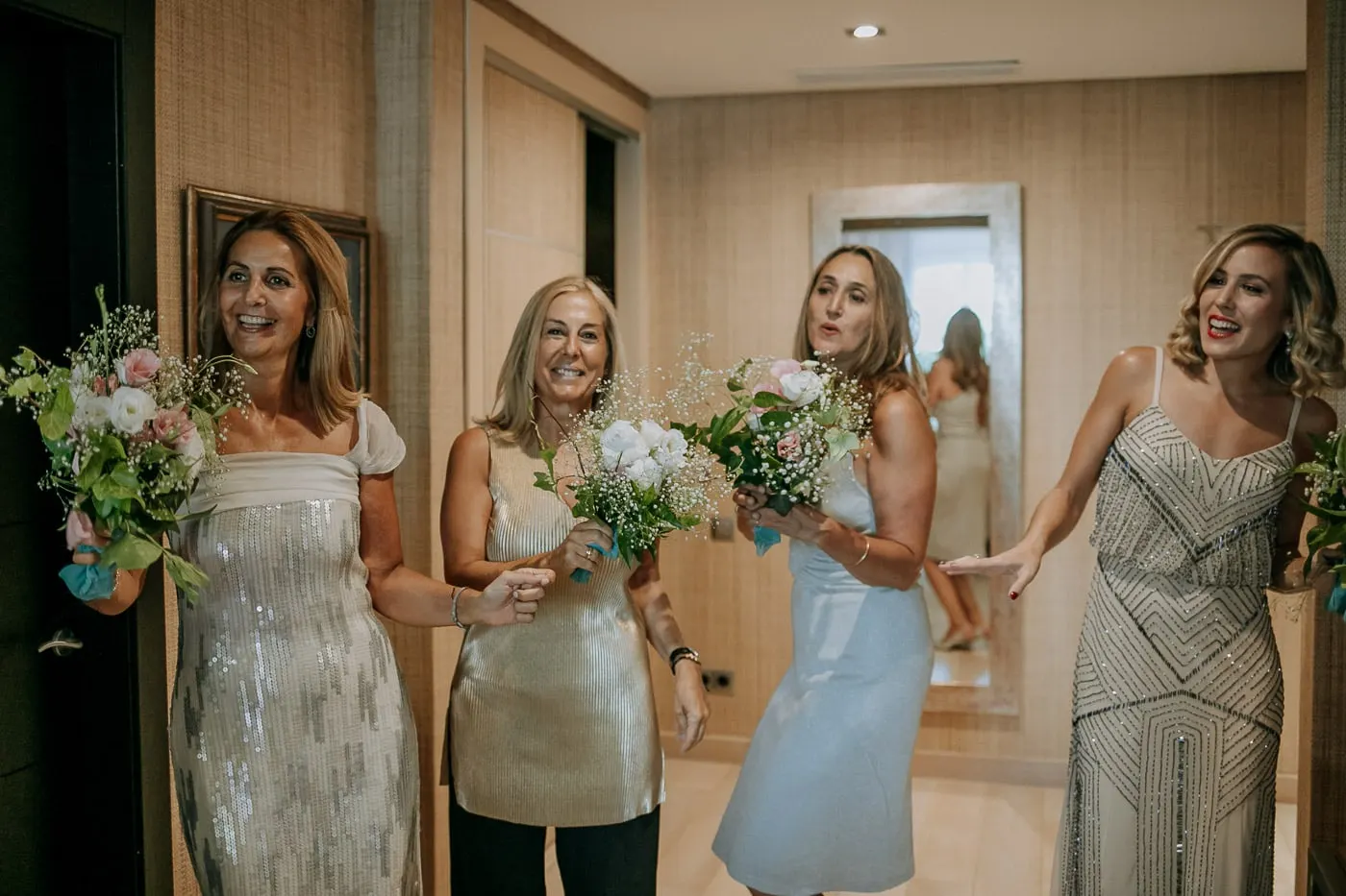 Friends with small bouquets seeing the bride dressed for the first time