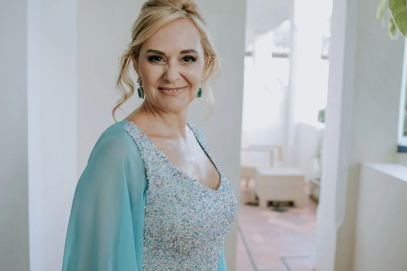 Portrait of the bride in a sequinned gown and emerald earrings