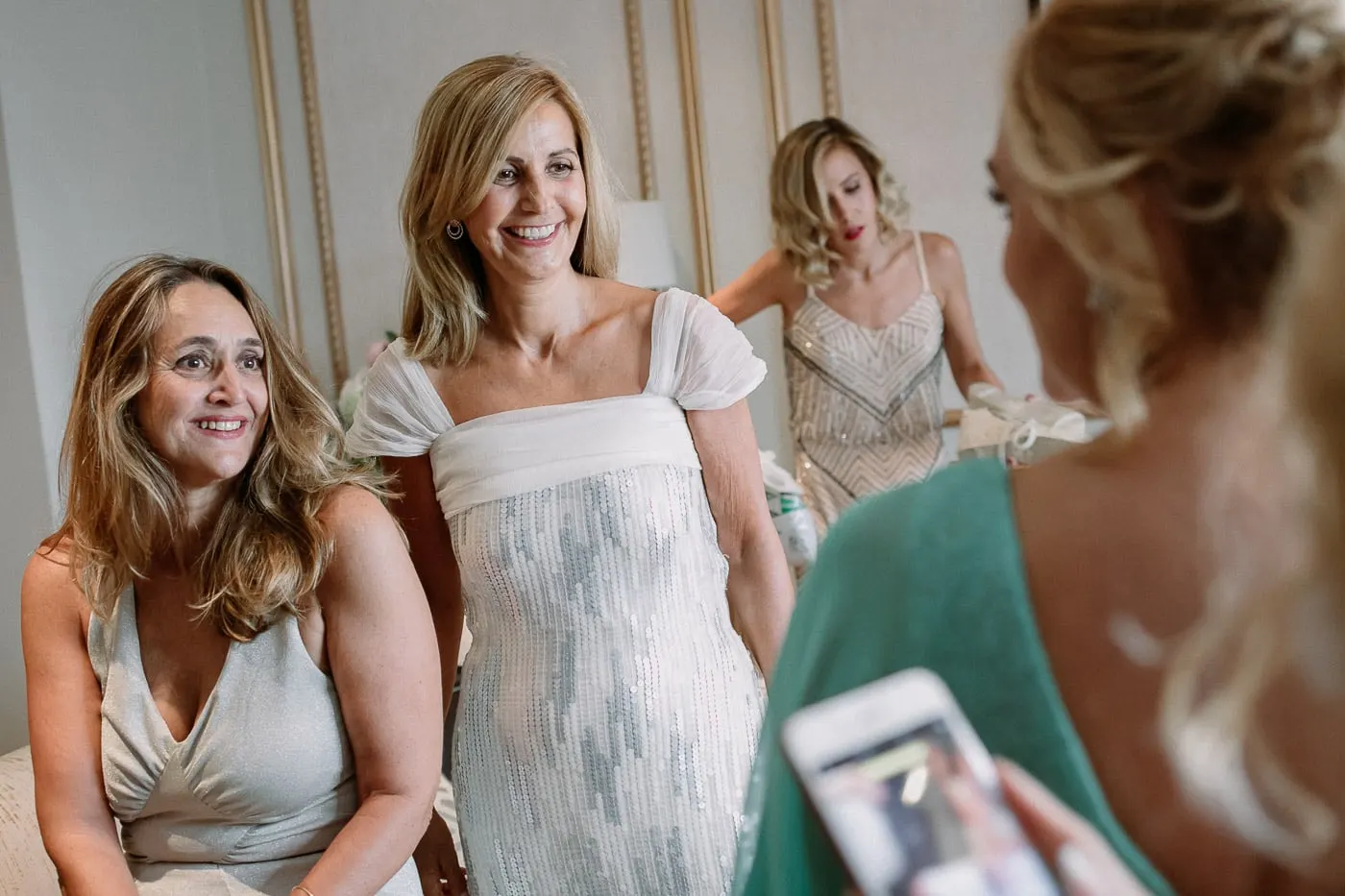 Friends smiling at the bride as she gets ready