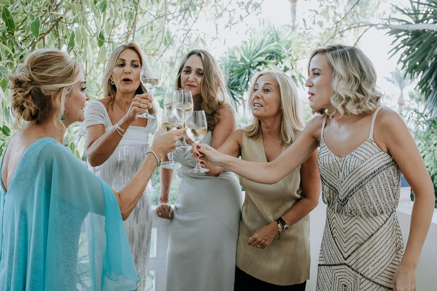 Bride and friends toasting with white wine on the balcony