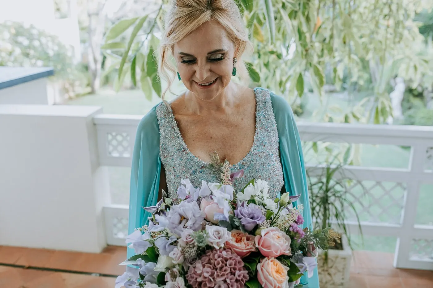 Bride looking down at her lilac and peach bouquet