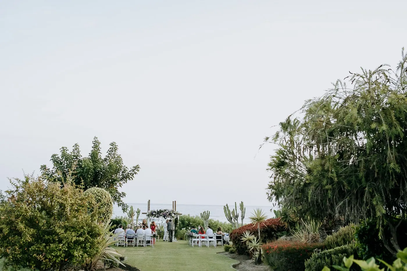 Ceremony set up at the end of the lawn with the sea beyond