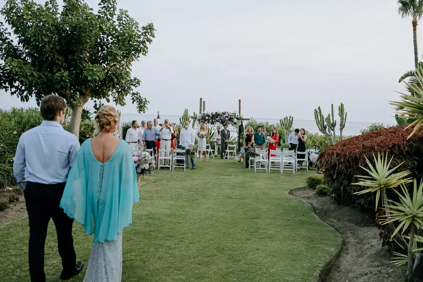 Bride's cape and the long aisle of white chairs on the lawn