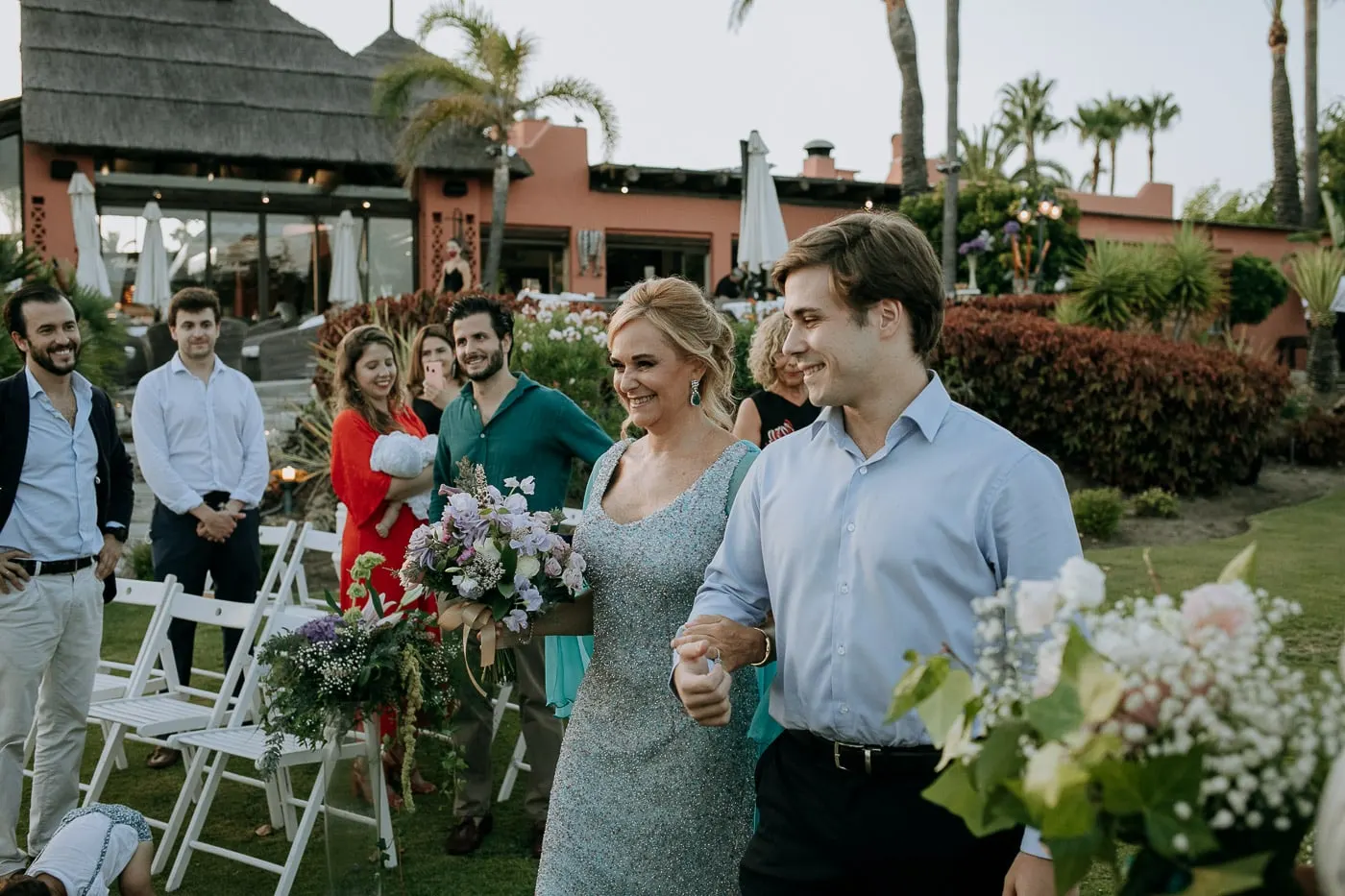 Bride entering the ceremony with the thatched restaurant behind, Tikitano