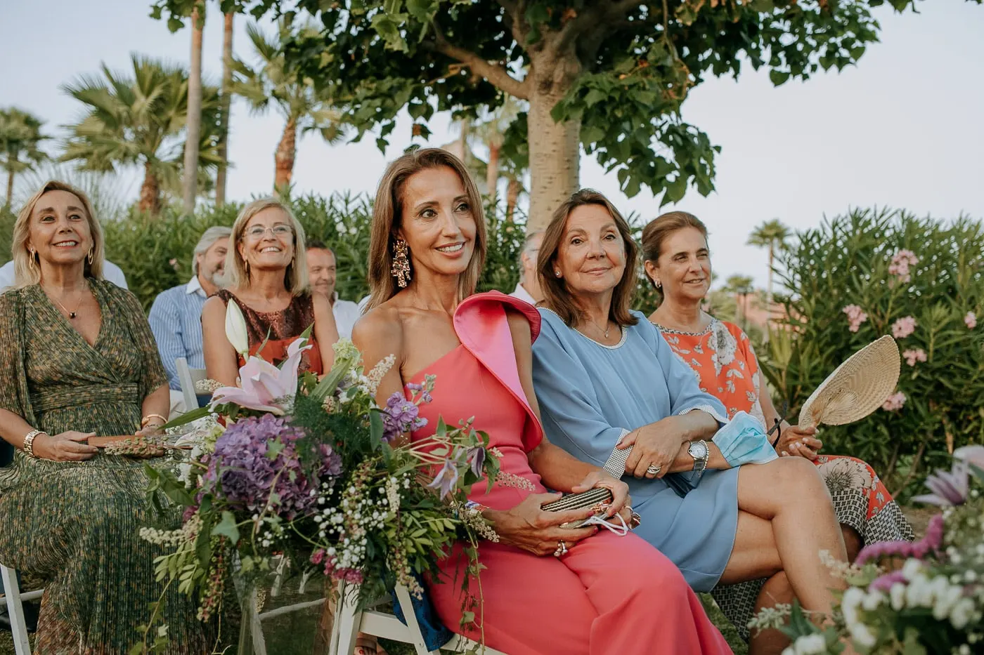 Guests among the flowers on the chairs during the ceremony