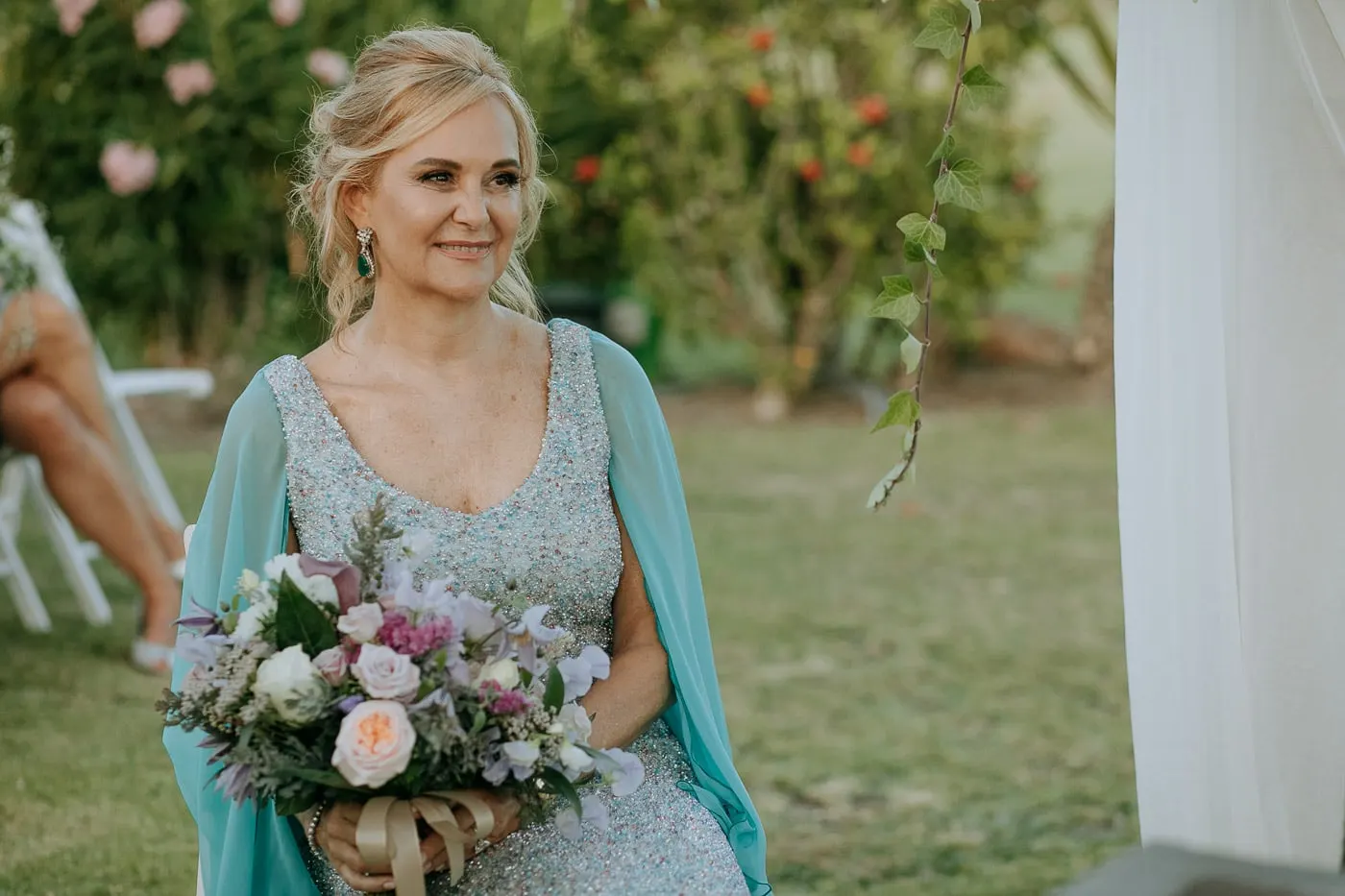 Bride smiling with her bouquet during the ceremony