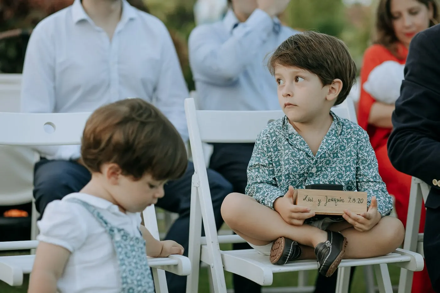 Little boy in the front row holding the box for the rings