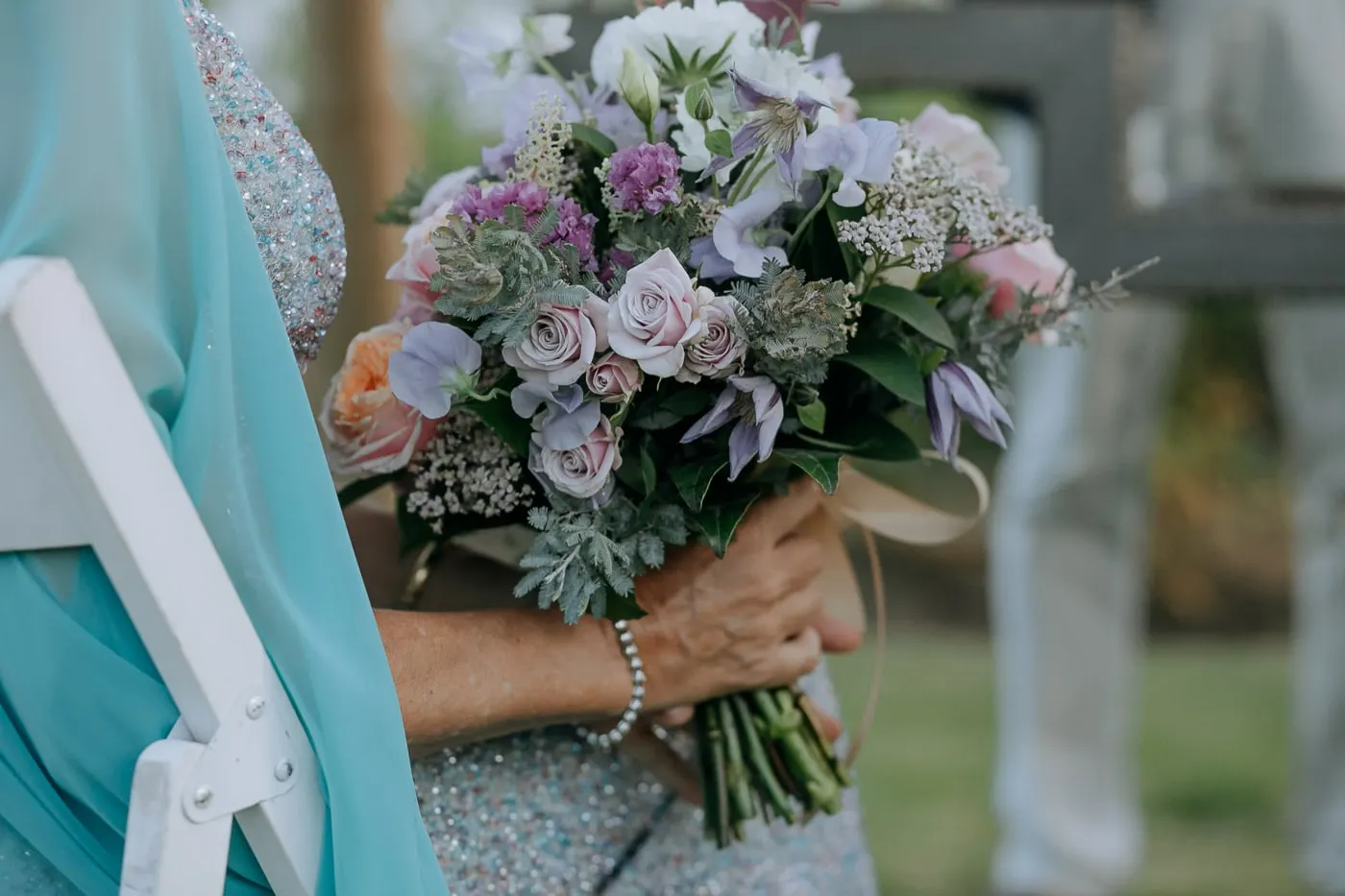Close-up of the lilac bouquet in the bride's hands