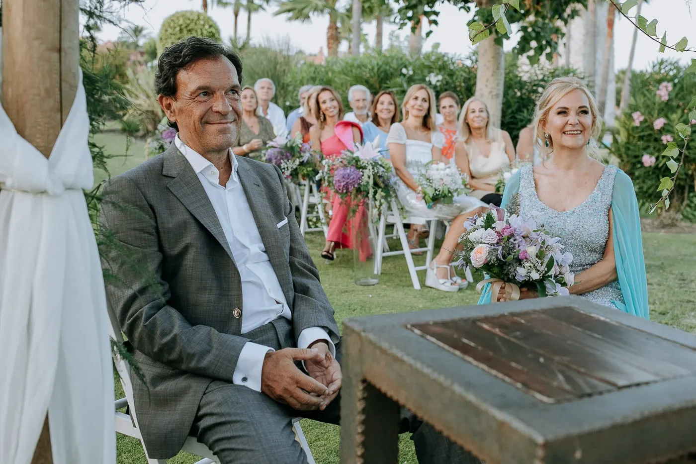 Bride and groom smiling in their seats in front of the guests, Estepona