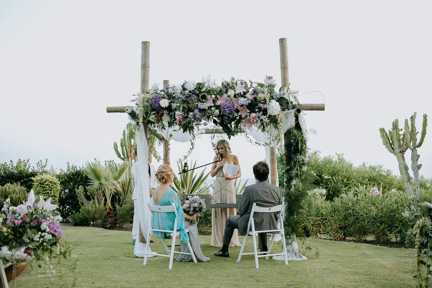 Reading under the flower arch, with cacti and the sea around