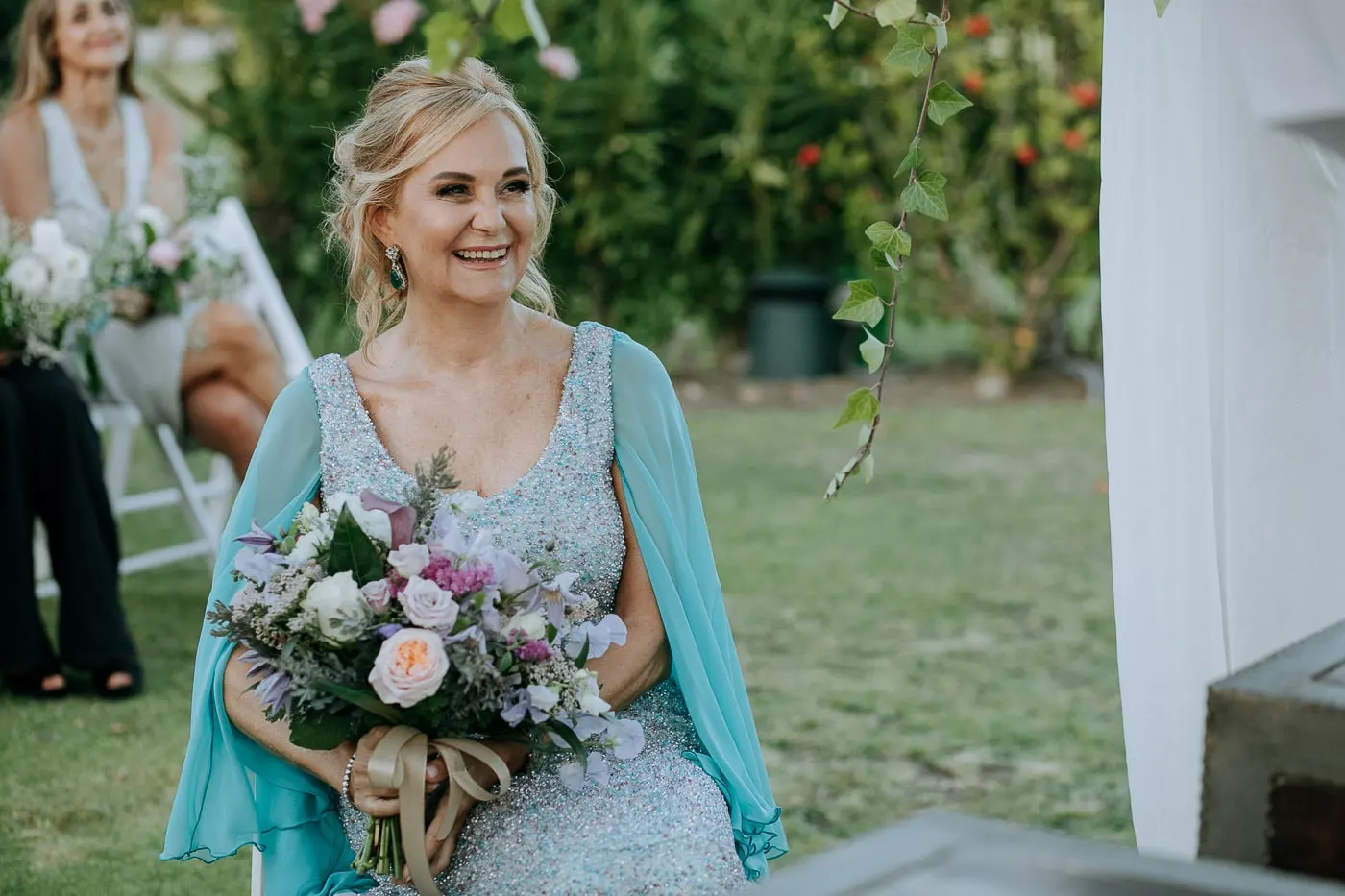 Bride laughing in her seat, her bouquet on her lap