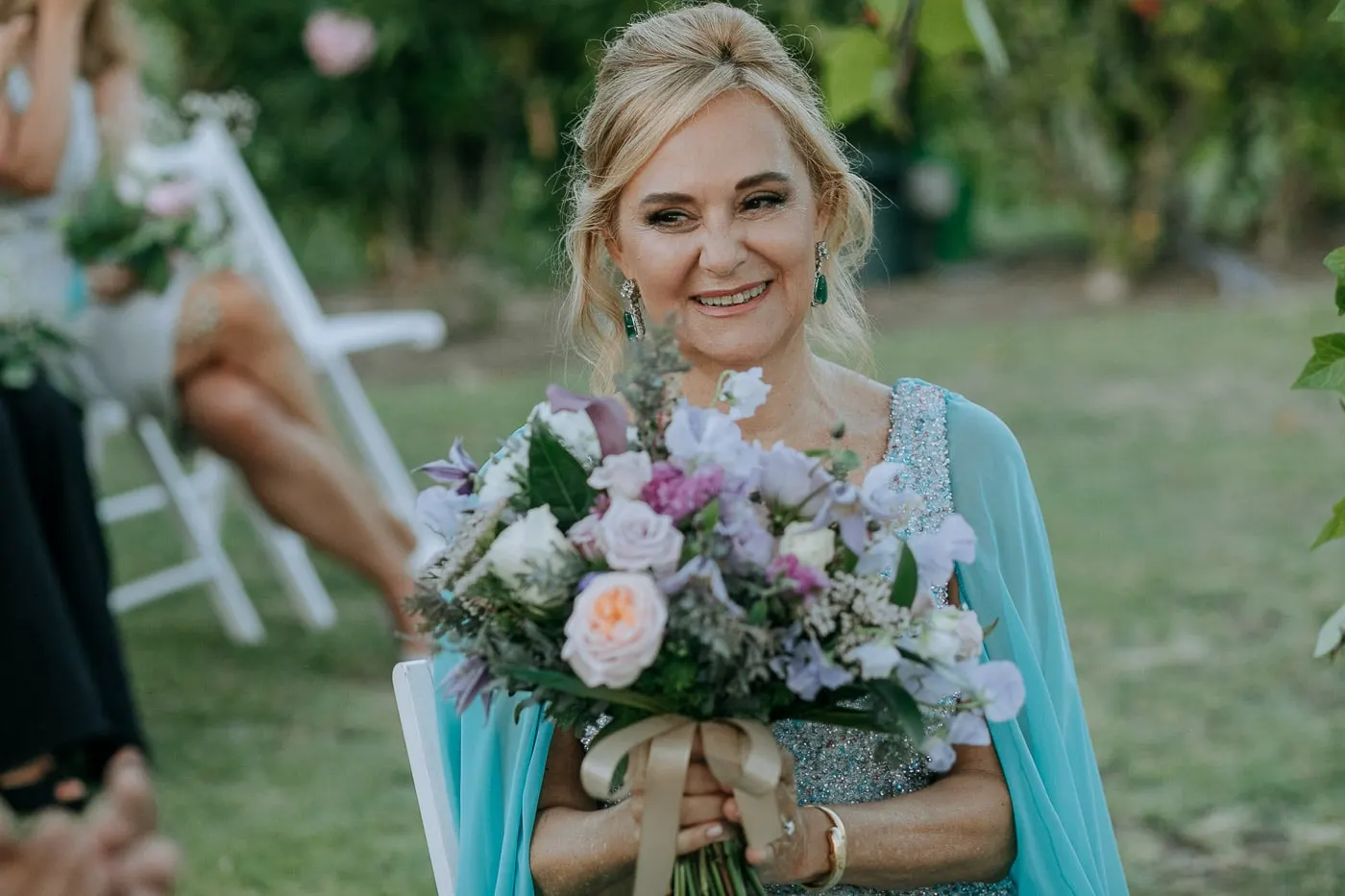 Bride smiling with her bouquet in the garden