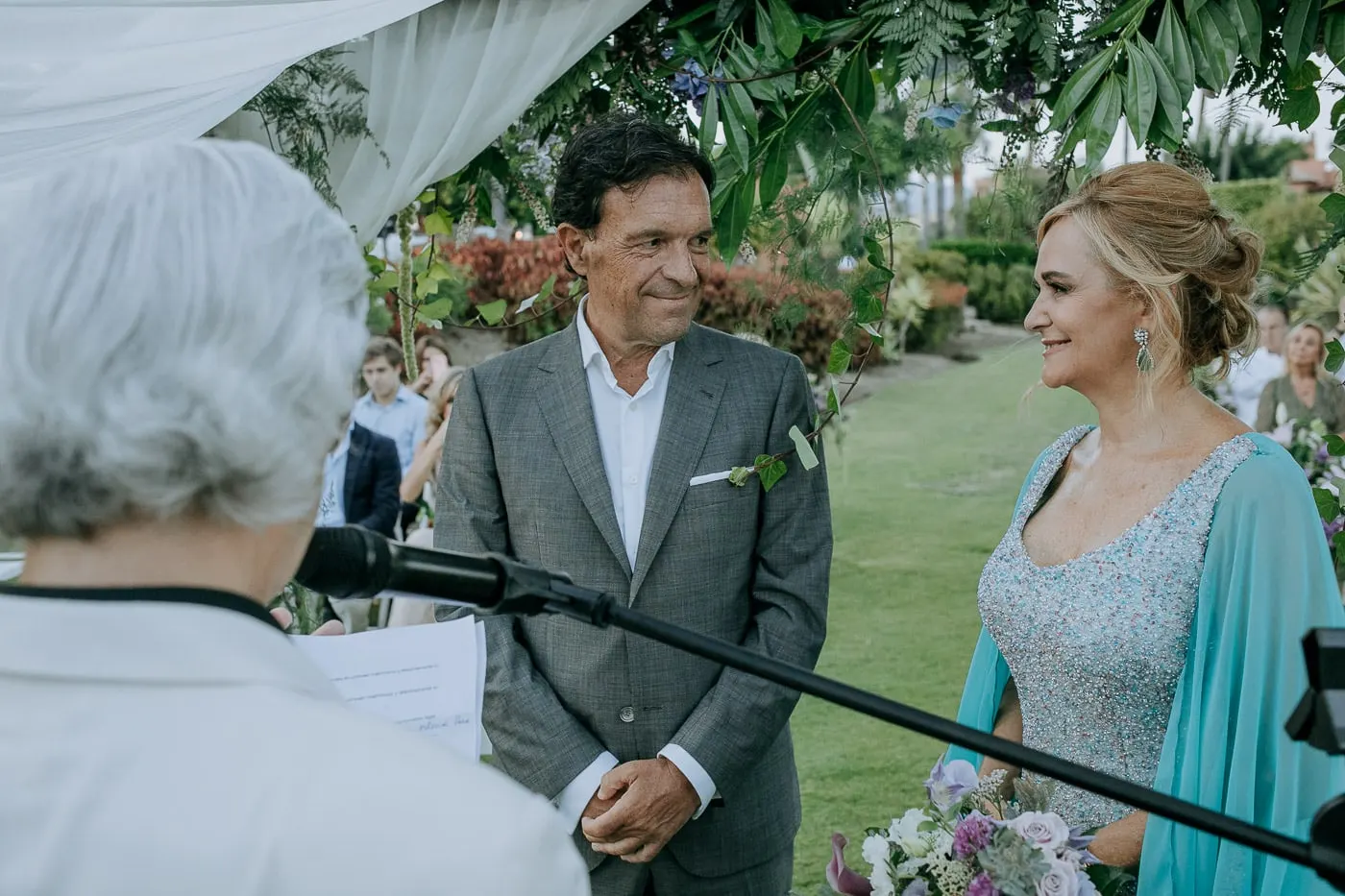 Groom and bride smiling at the officiant