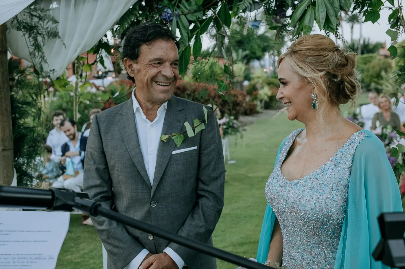 Groom laughing beside the bride at the microphone