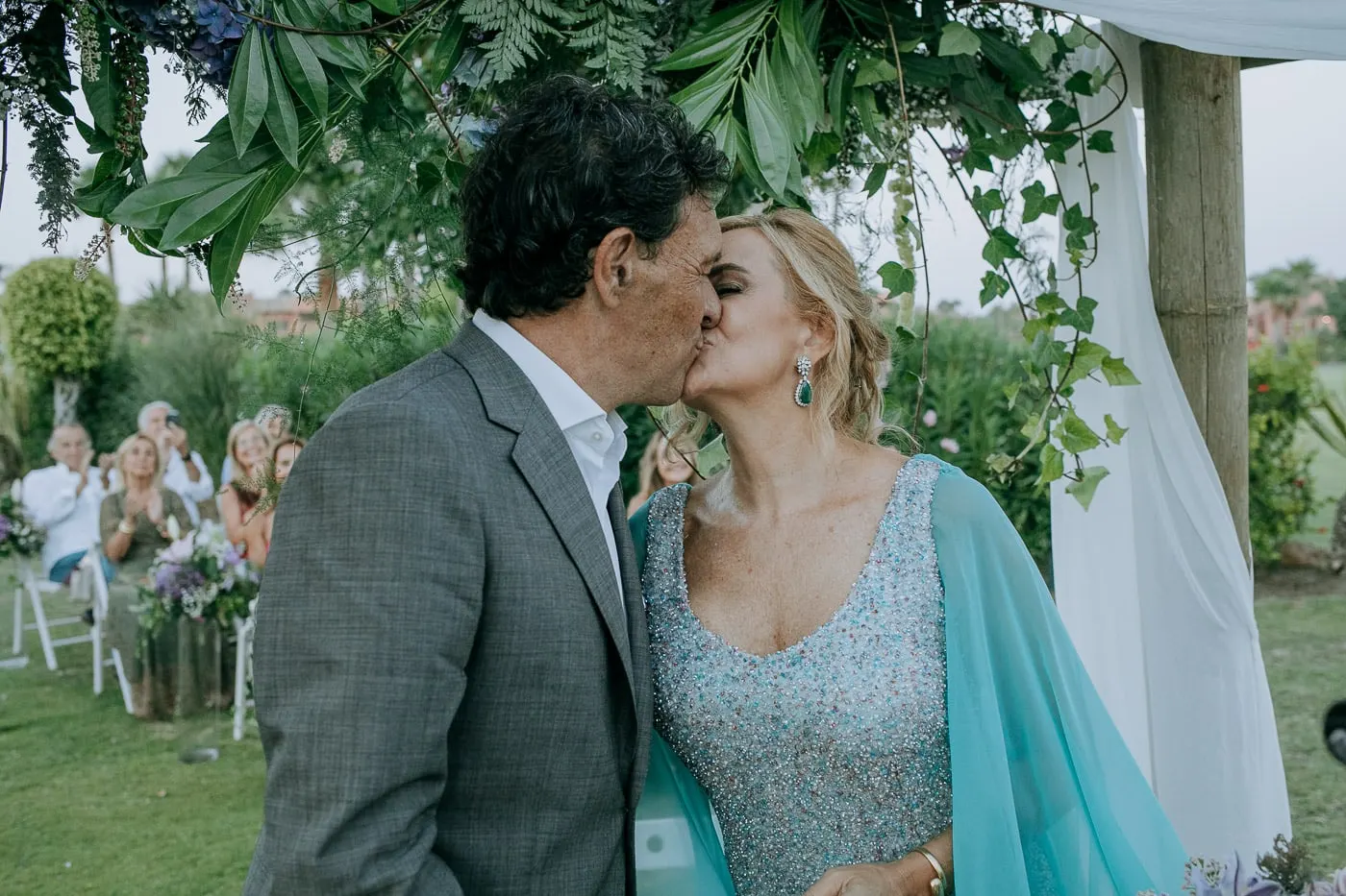 First kiss as a married couple while the guests clap