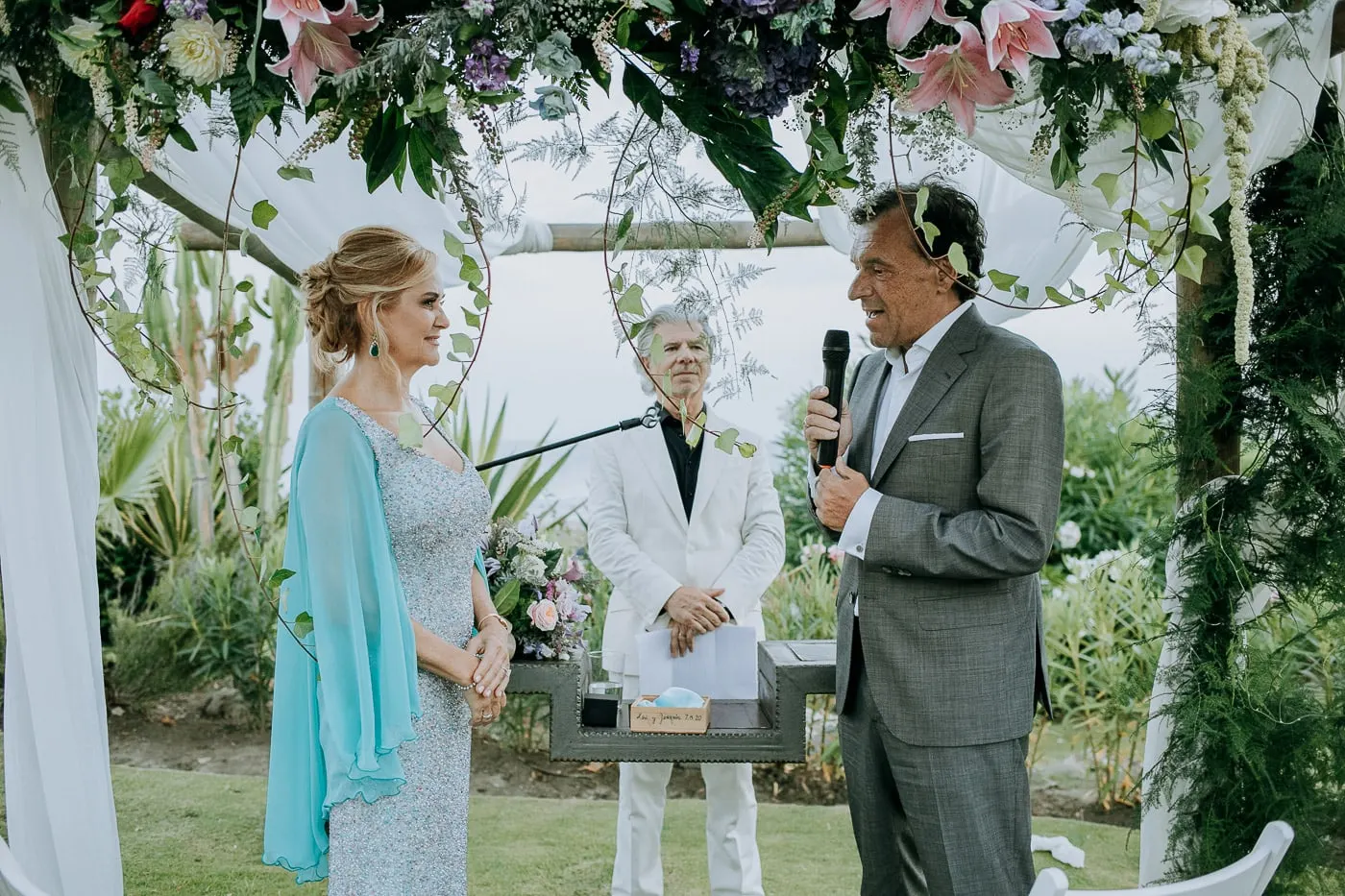 Groom speaking at the microphone as the bride listens