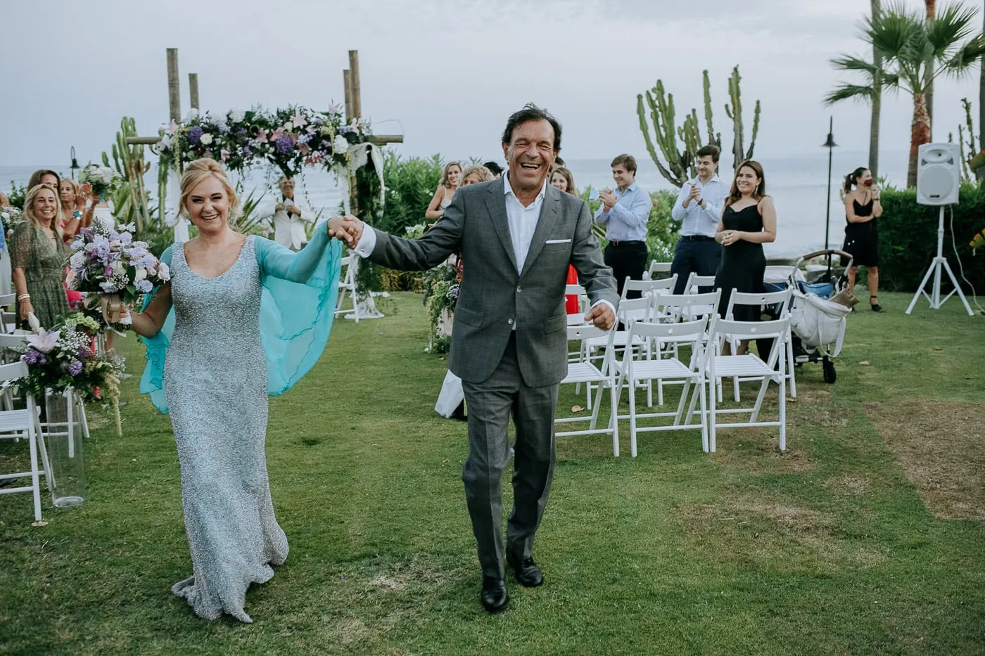 Bride raising the groom's hand as they walk out