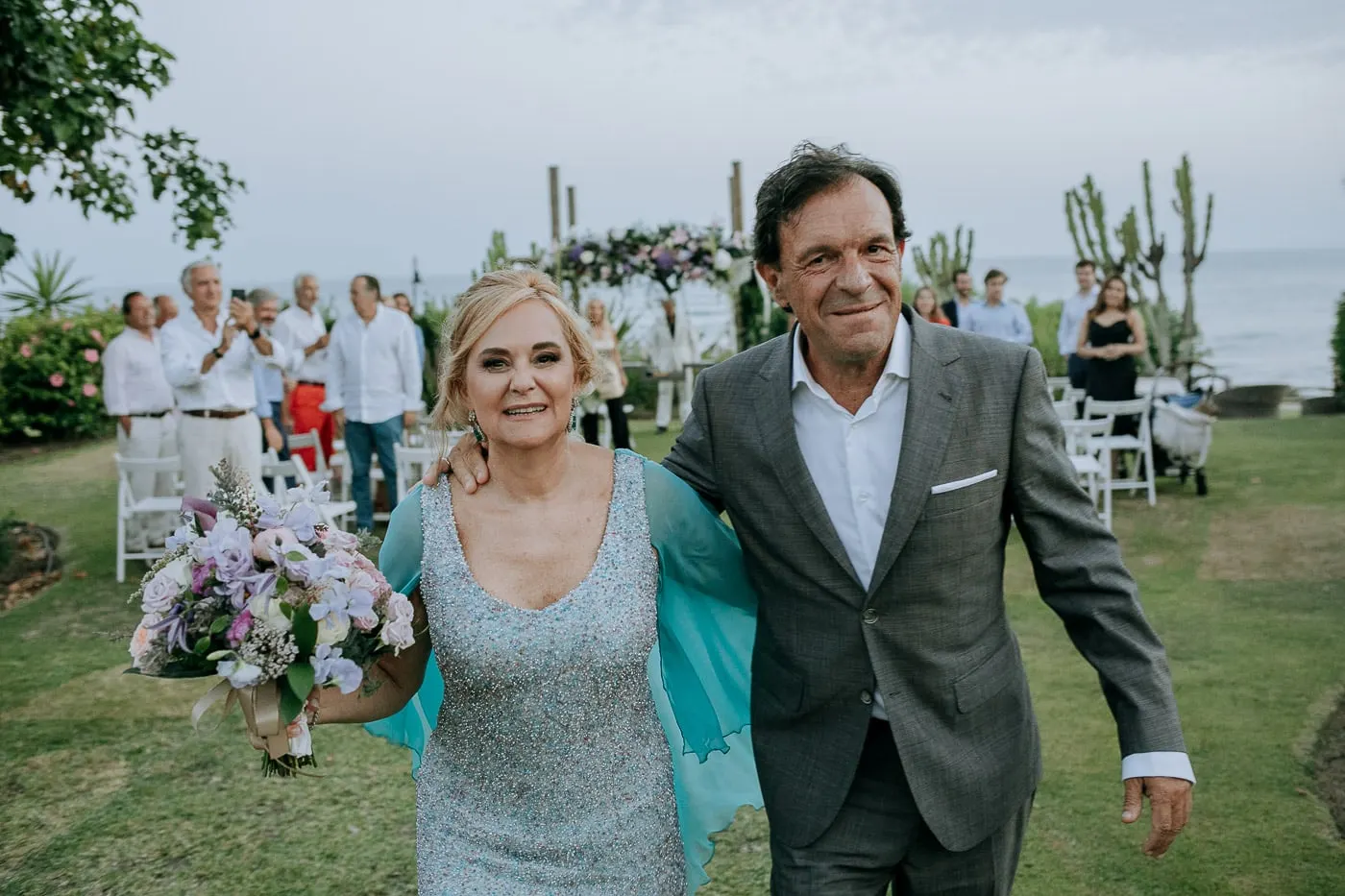 Newlyweds smiling arm in arm with the guests behind, Estepona