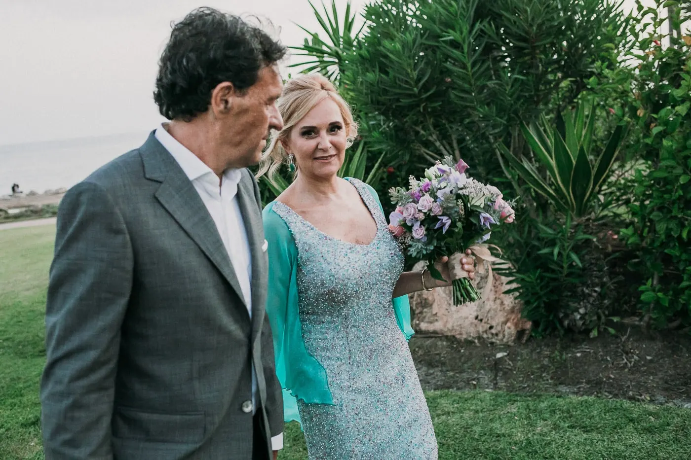Groom looking at the bride among the garden's palms and agaves