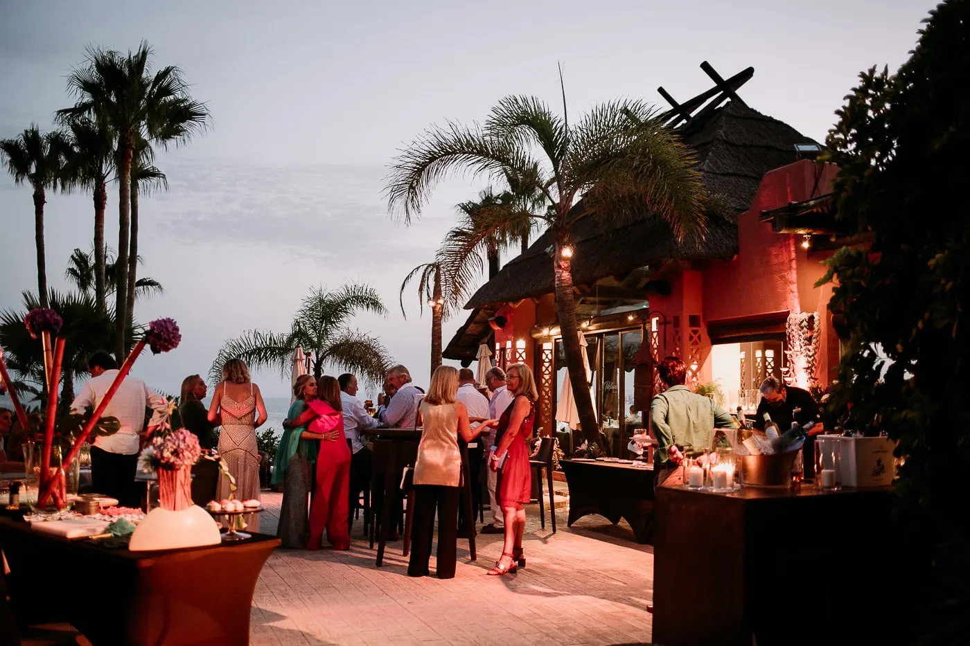 Cocktail hour at dusk under the thatched roof and palms of Tikitano