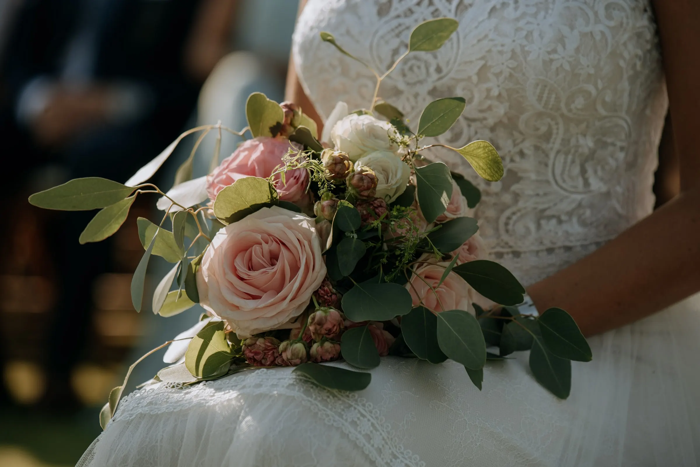 Close-up of the bride's bouquet of pink roses and eucalyptus against her lace dress, Trocadero, Sotogrande