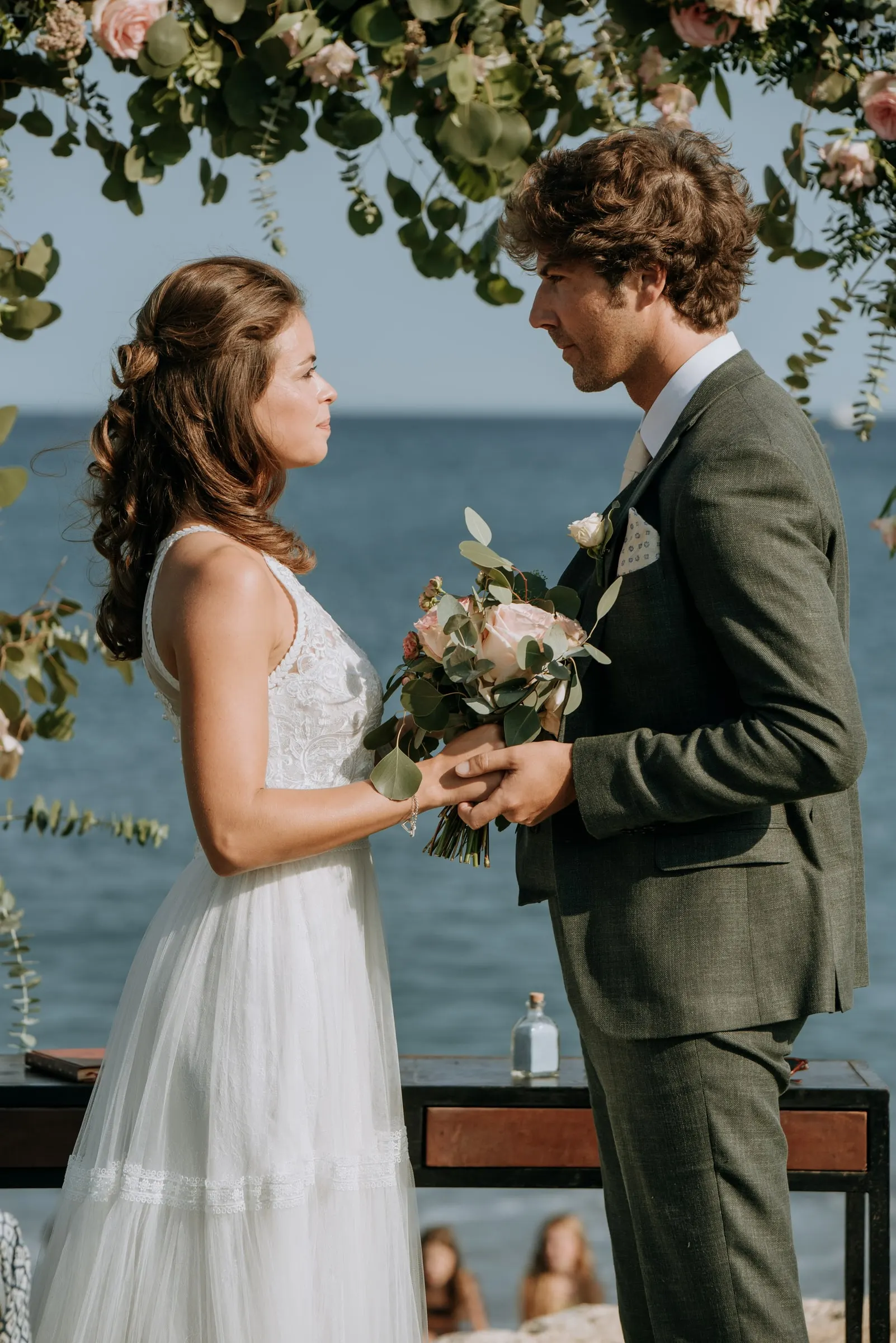 Bride and groom holding hands in front of the officiant's table and the sea, Trocadero, Sotogrande