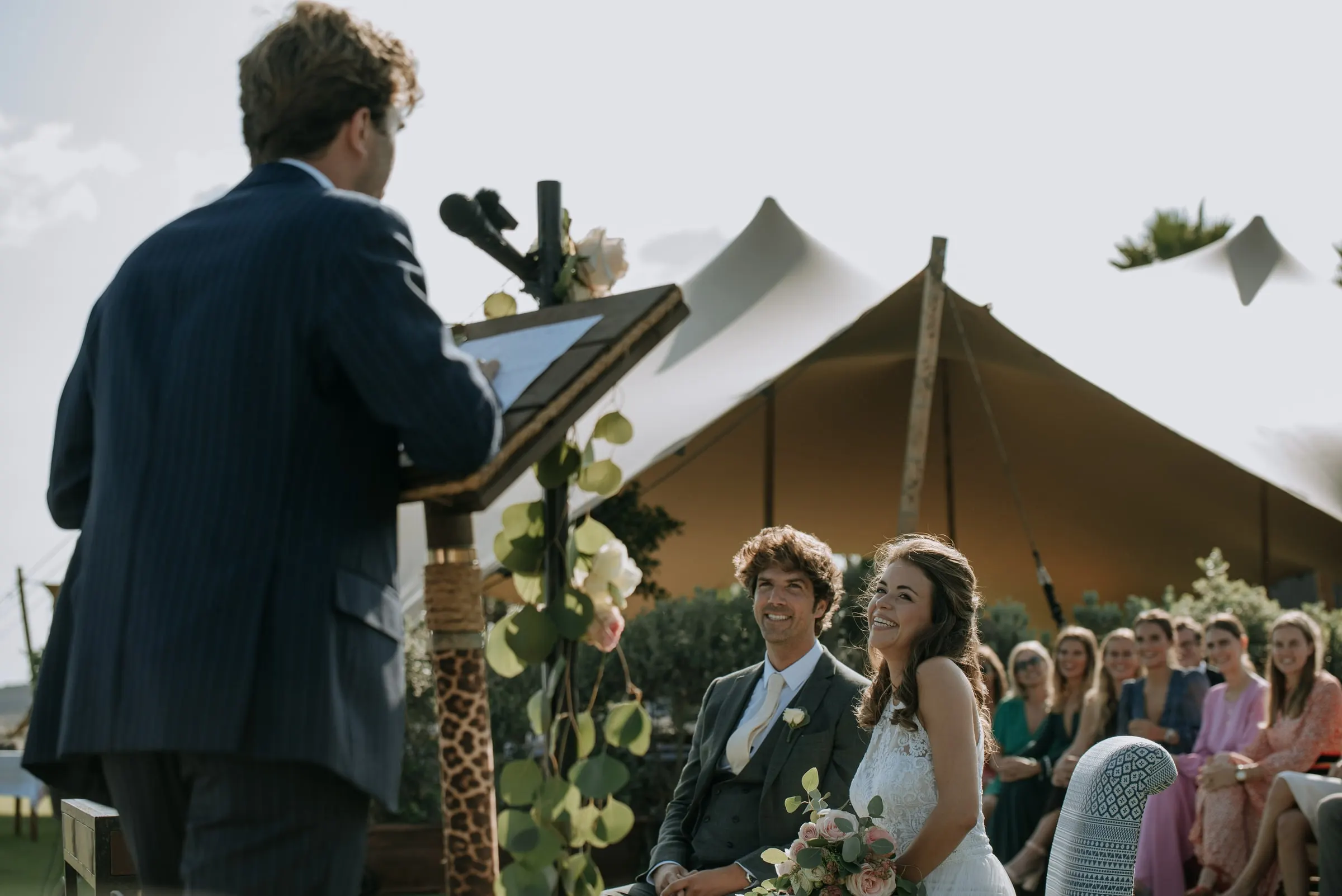 A guest giving a reading at the lectern as the seated couple listen, Trocadero, Sotogrande